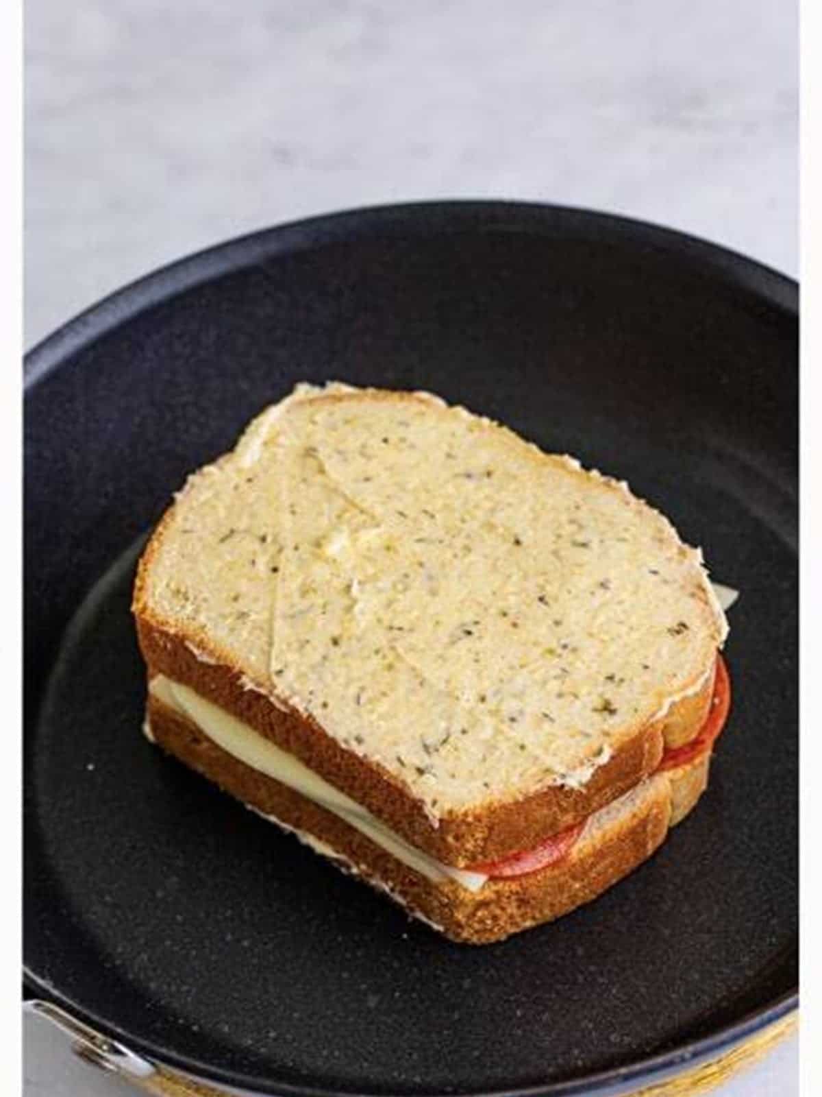 Topping the Pizza Sandwich with a second slice of bread.