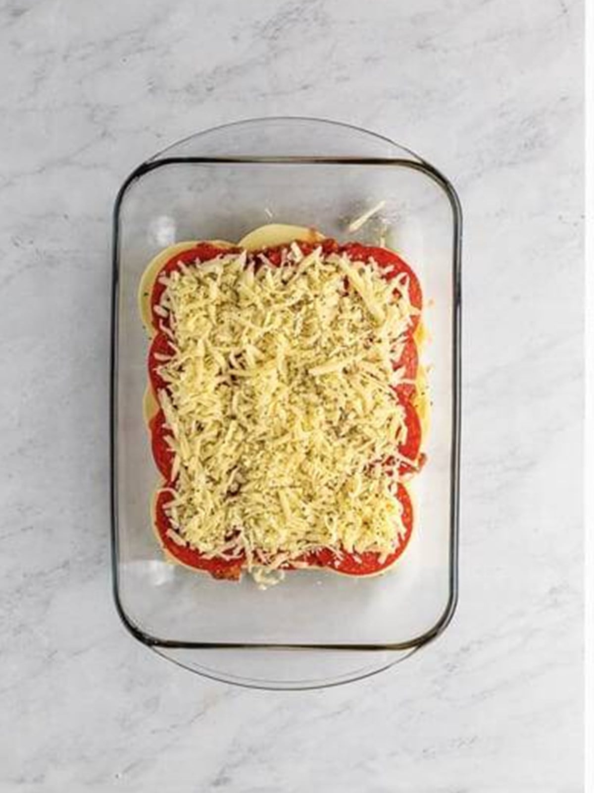 Shredded mozzarella sprinkled over the pepperoni before adding the top rolls.