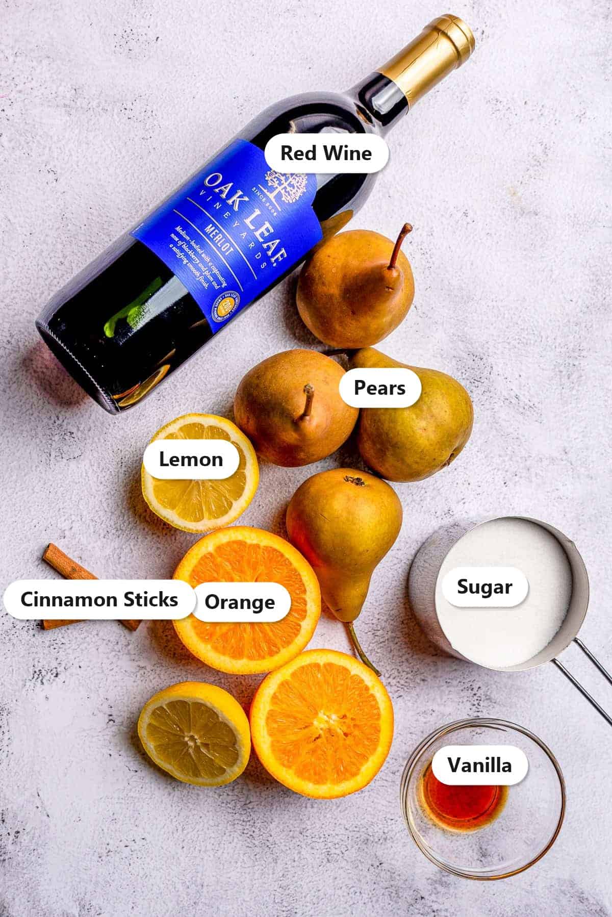 Labeled ingredients to make red wine poached pears: red wine, pears, lemon, orange, cinnamon sticks, sugar, and vanilla.