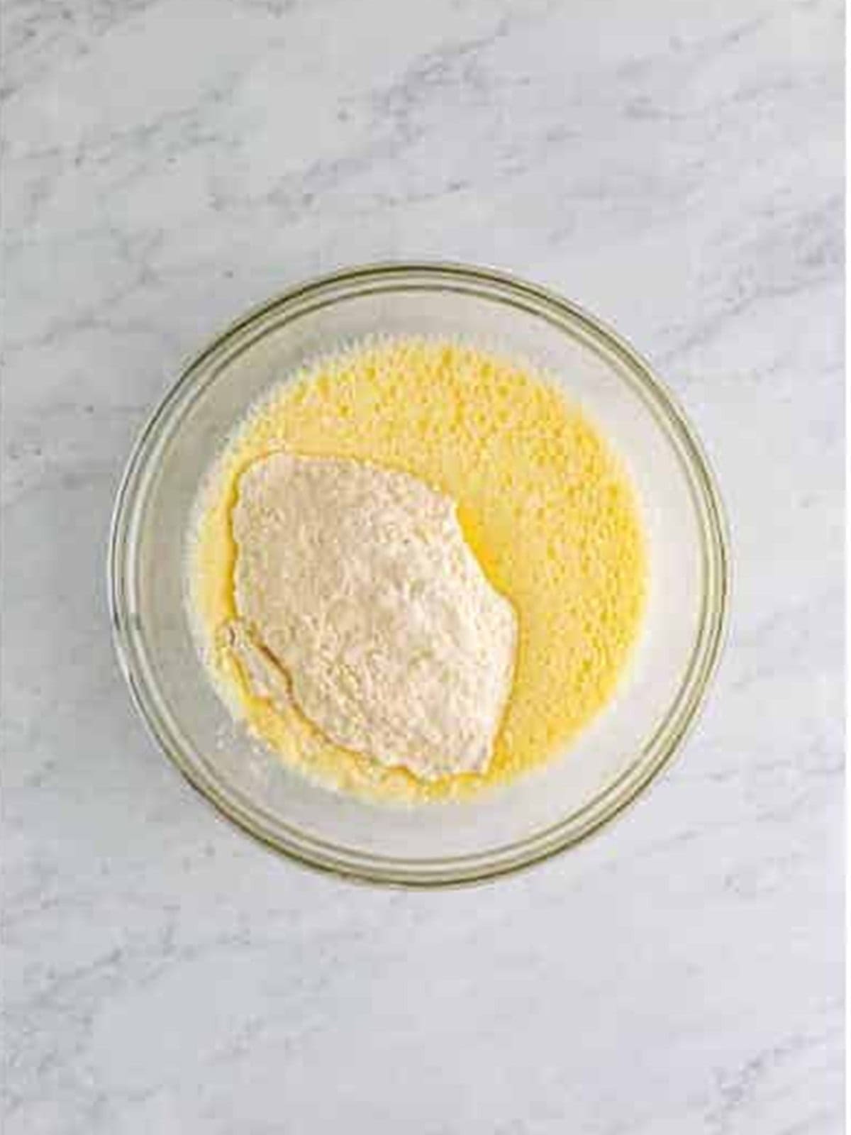 Flour and salt added to the whisked eggs and milk.