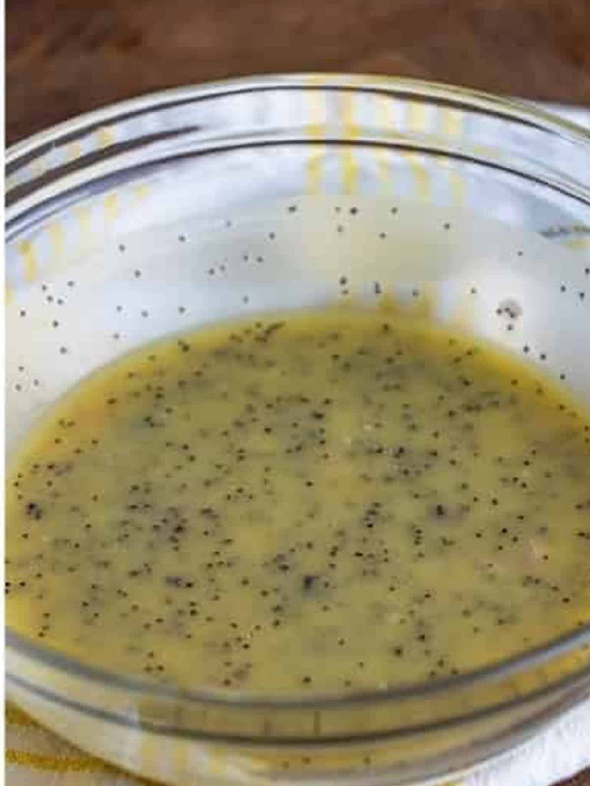 The finished homemade poppy seed dressing stirred together in a glass bowl.