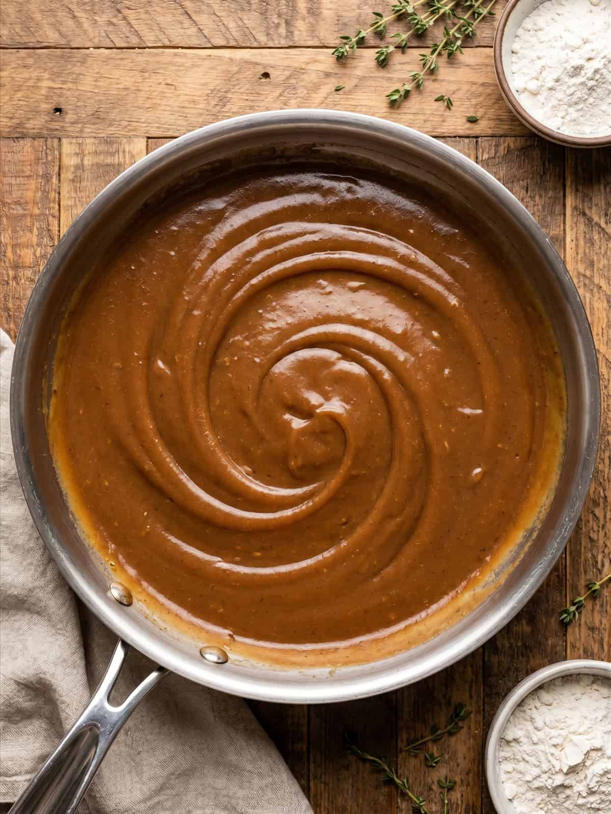 Rich brown gravy thickened with a cornstarch slurry in a skillet.