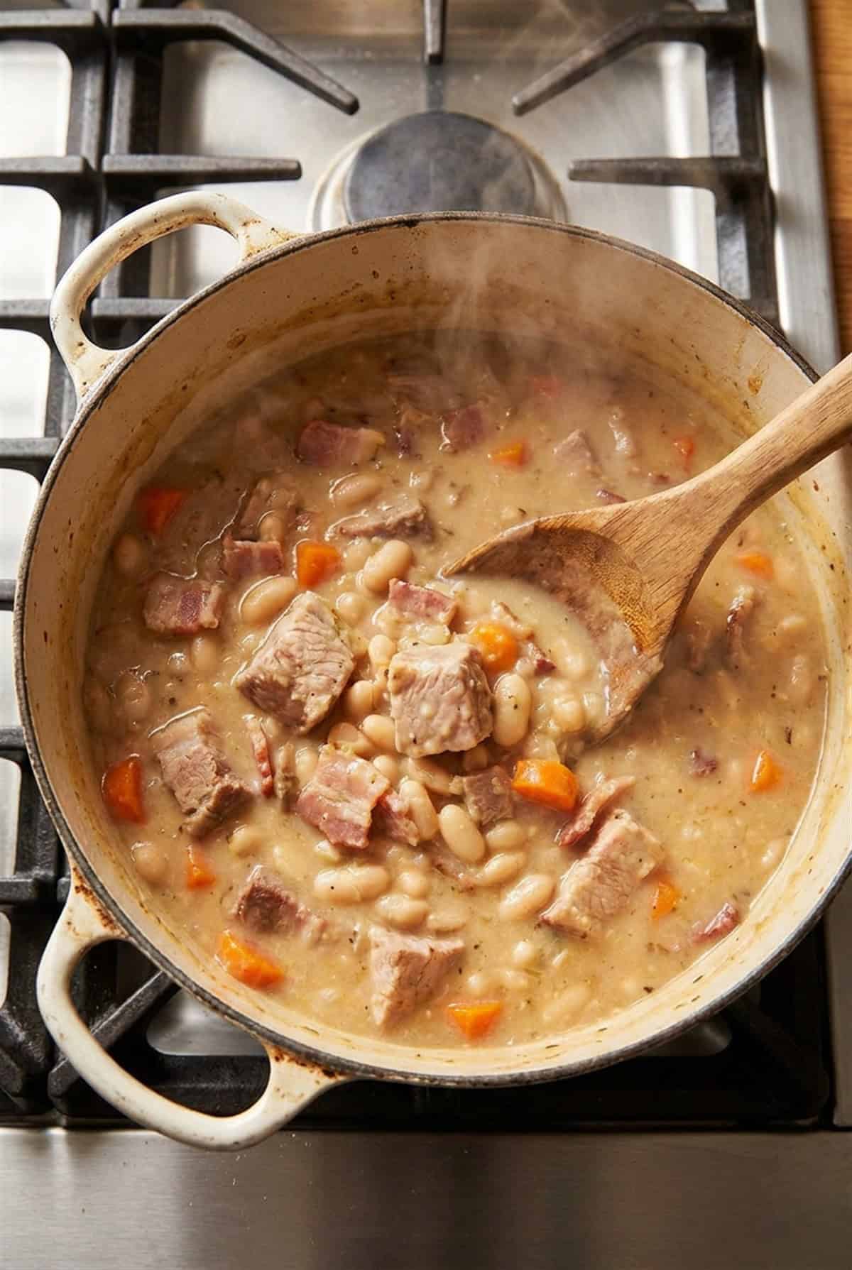 A Dutch oven of creamy White Bean and Pork Stew simmering on the stove.