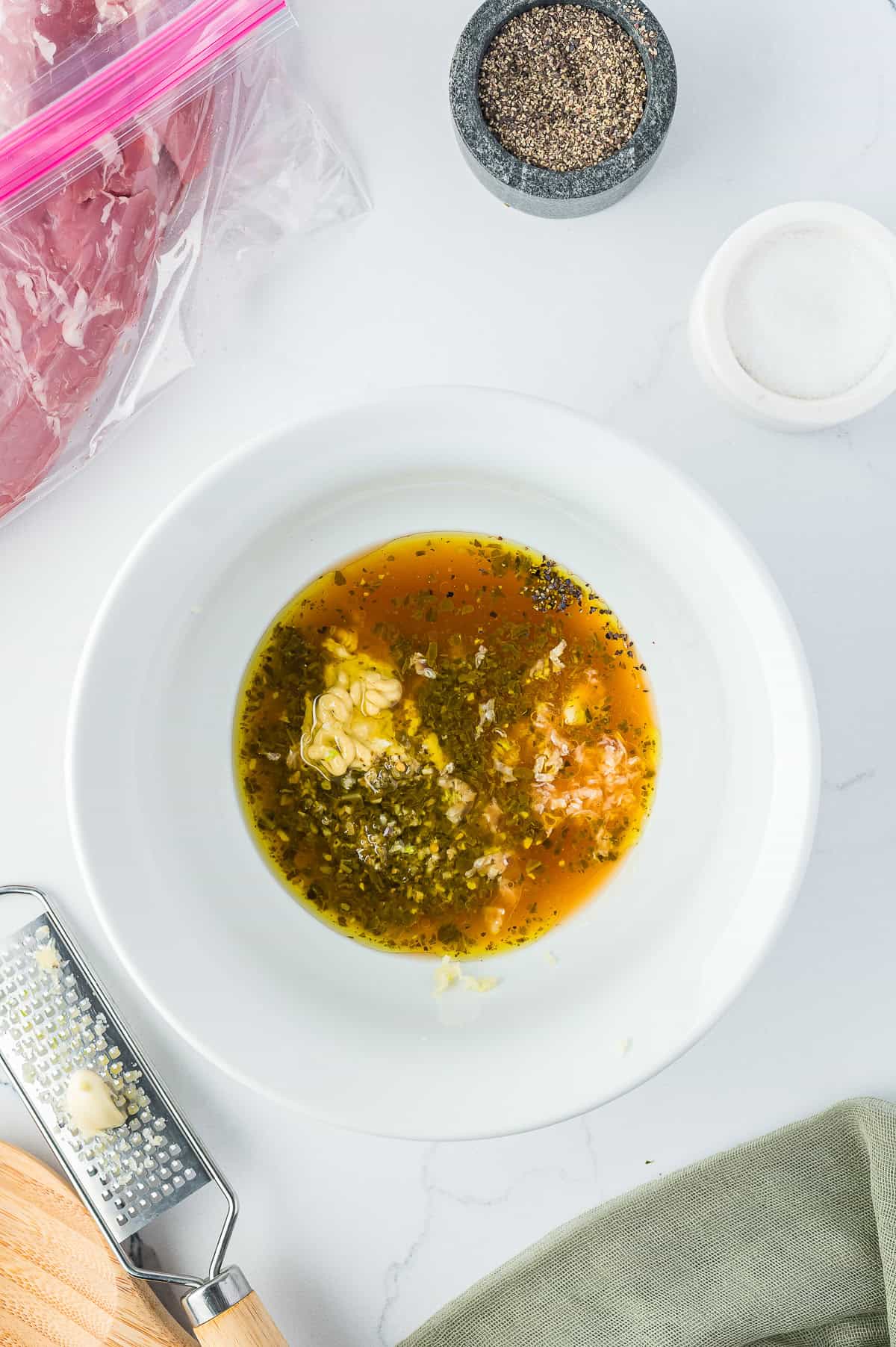 Brown sugar balsamic marinade whisked together in a white bowl for pork tenderloin.