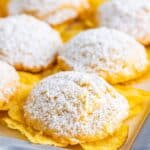 Powdered sugar dusted potato chip cookies on a baking tray.