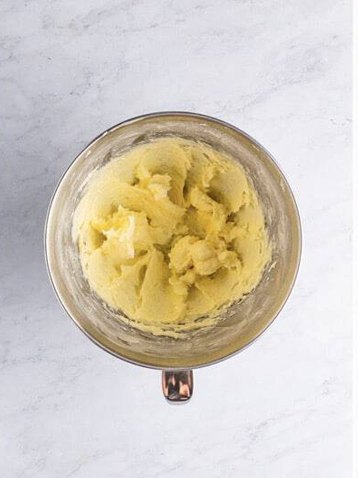 Butter and sugar creamed together in a mixing bowl.