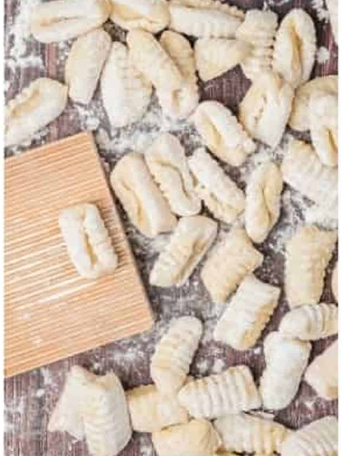 Cut potato gnocchi pieces rolled over a gnocchi board to form ridges.