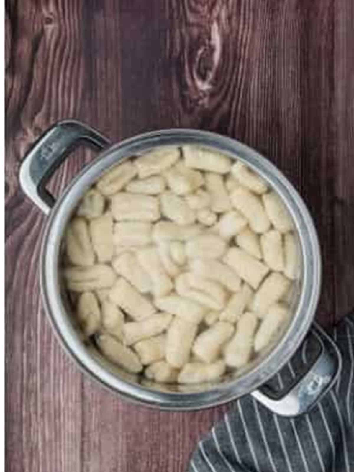 Potato gnocchi cooking in a pot of boiling water until they float to the top.