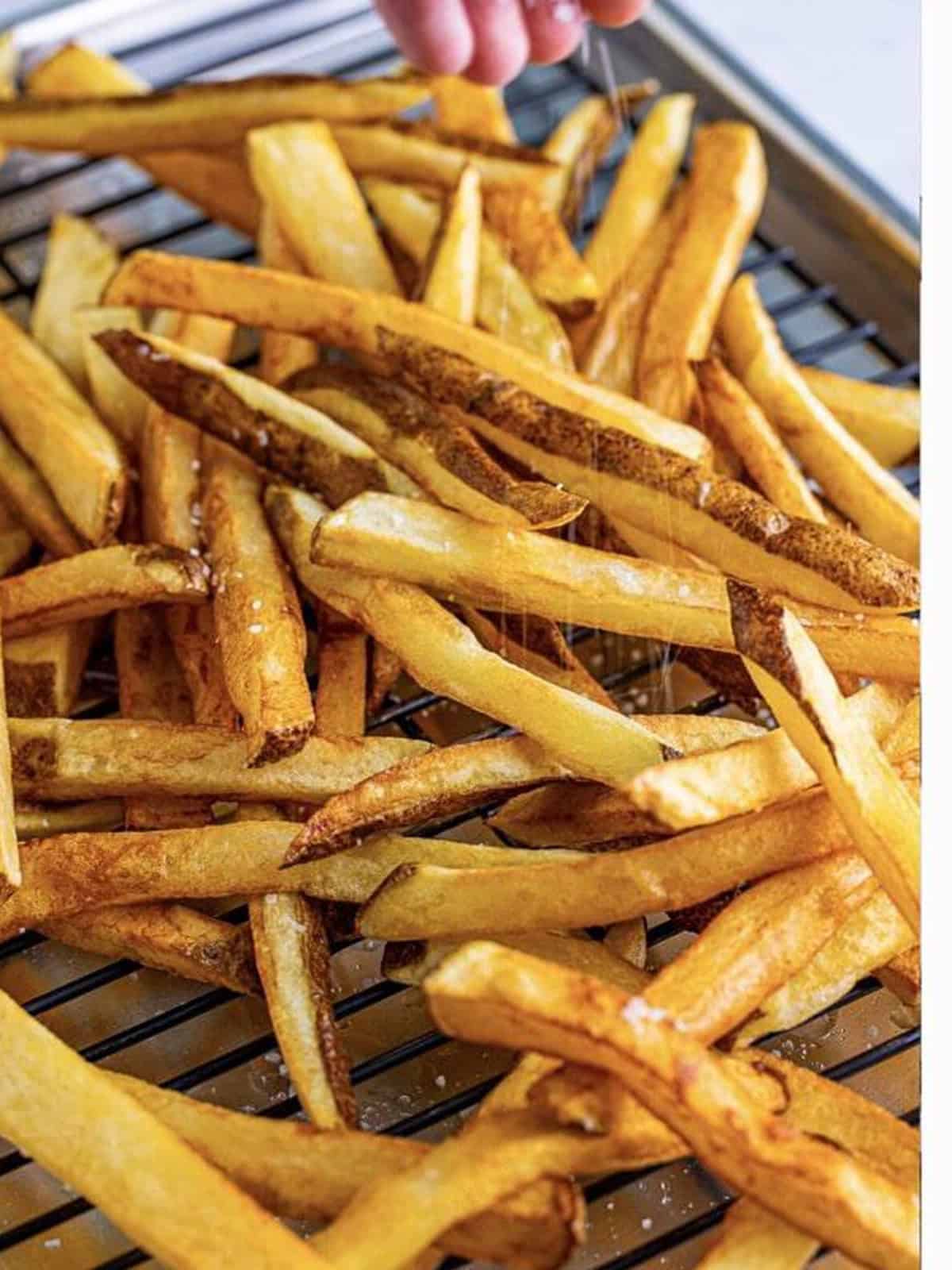 Crispy double-fried poutine fries on a wire rack.