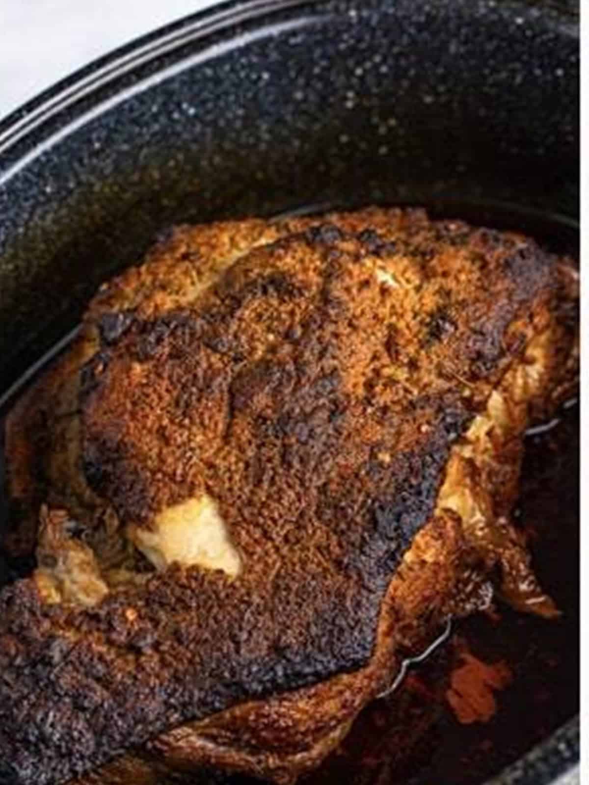 Oven baked pork shoulder browned and tender after roasting.