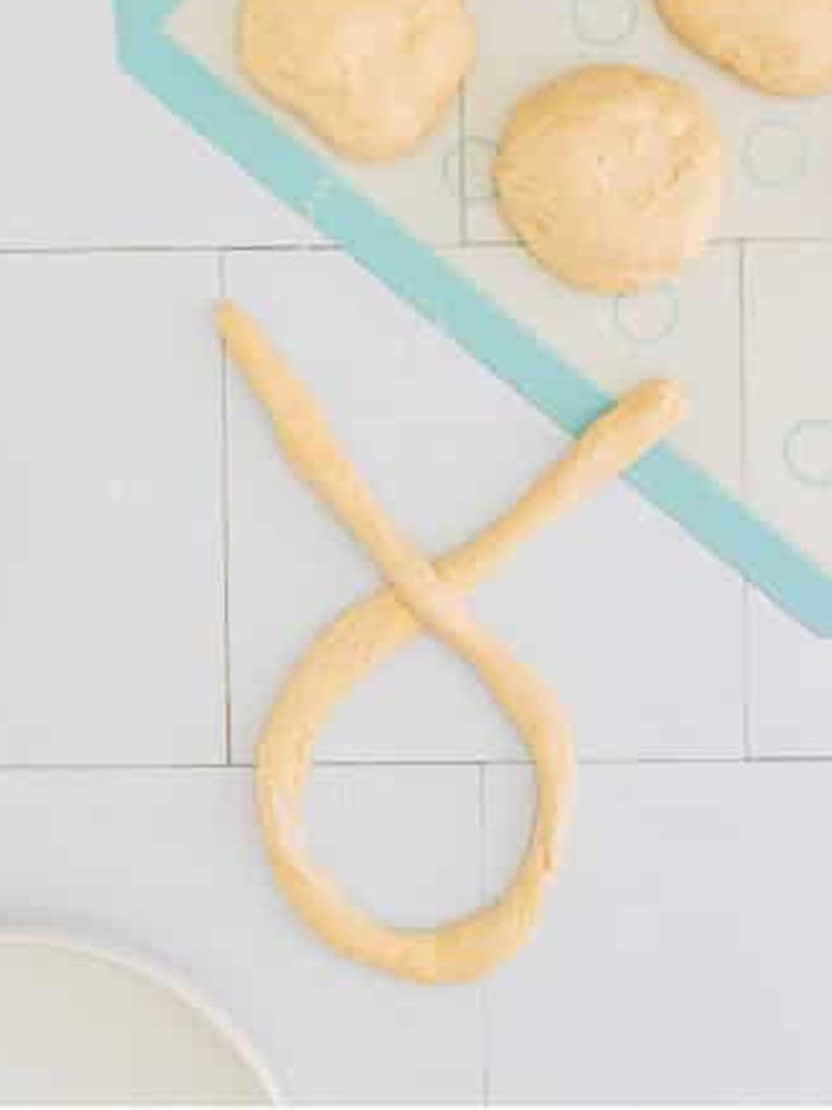 A long rope of dough twisted into a classic pretzel shape.