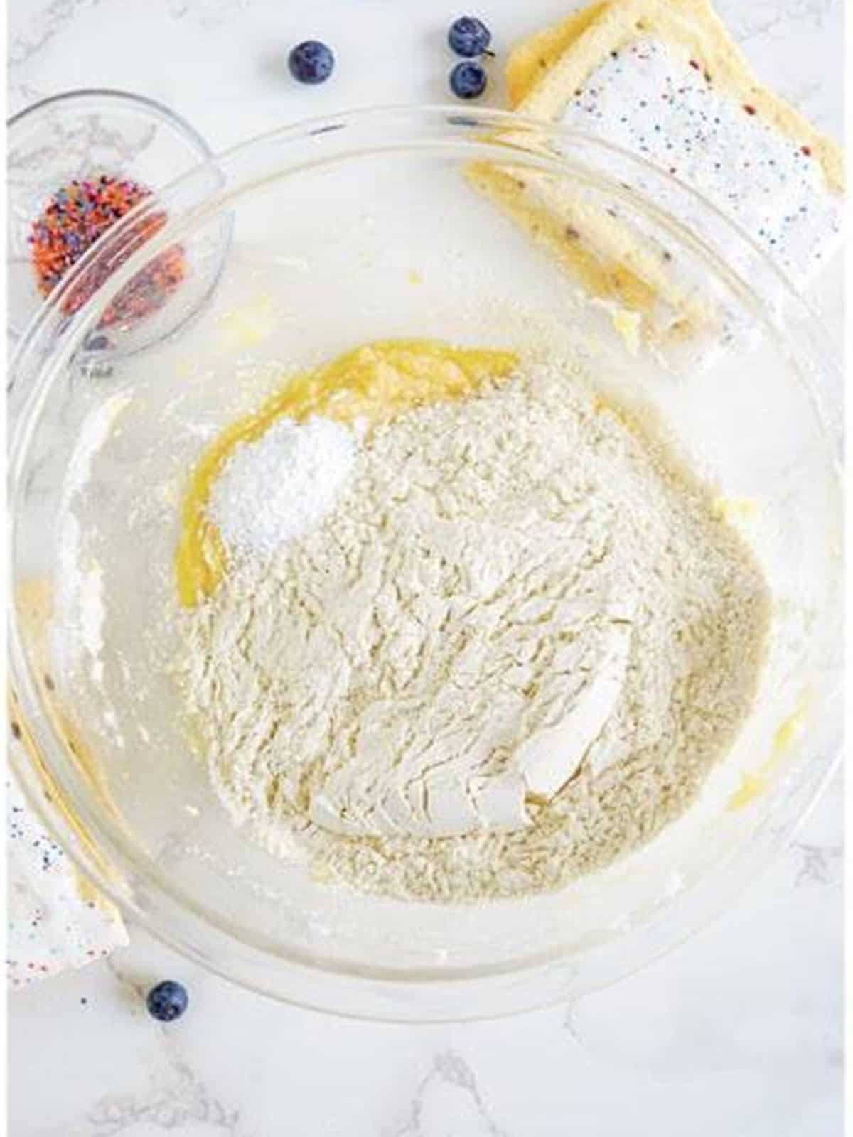 Flour, baking powder, and salt added to the creamed butter and sugar.
