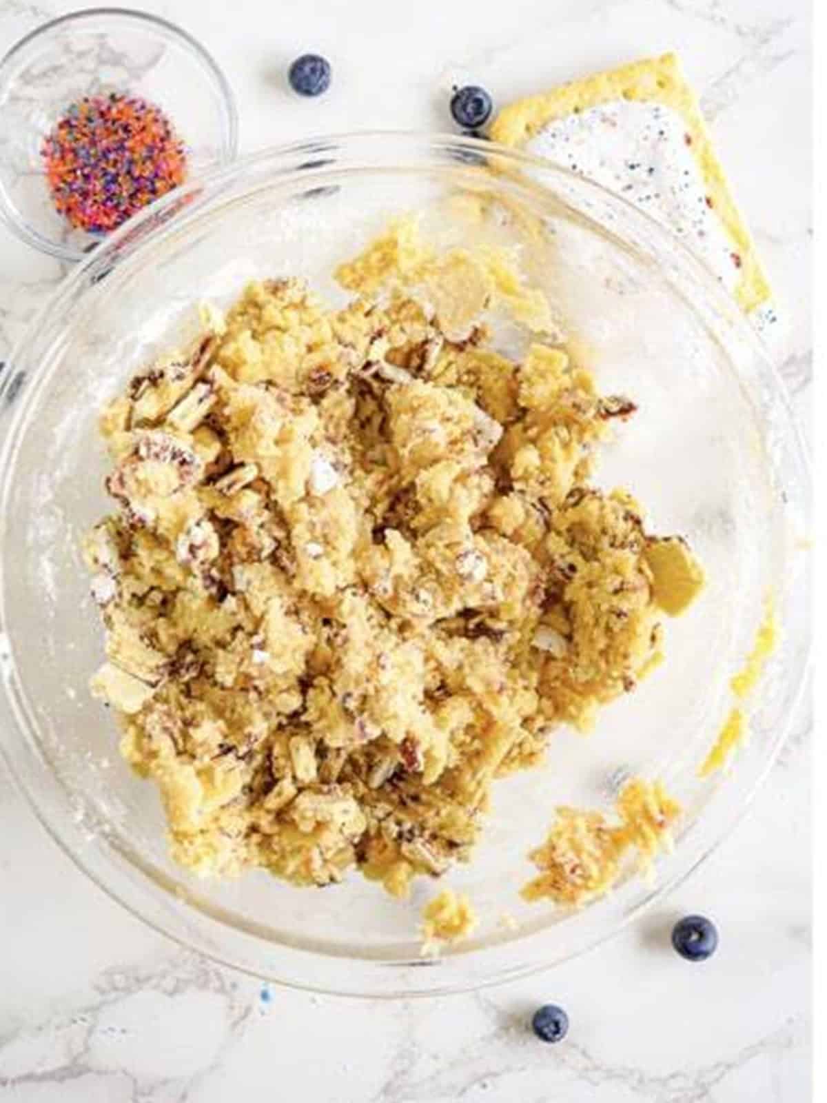 Crushed blueberry Pop-Tarts being folded into sugar cookie dough.