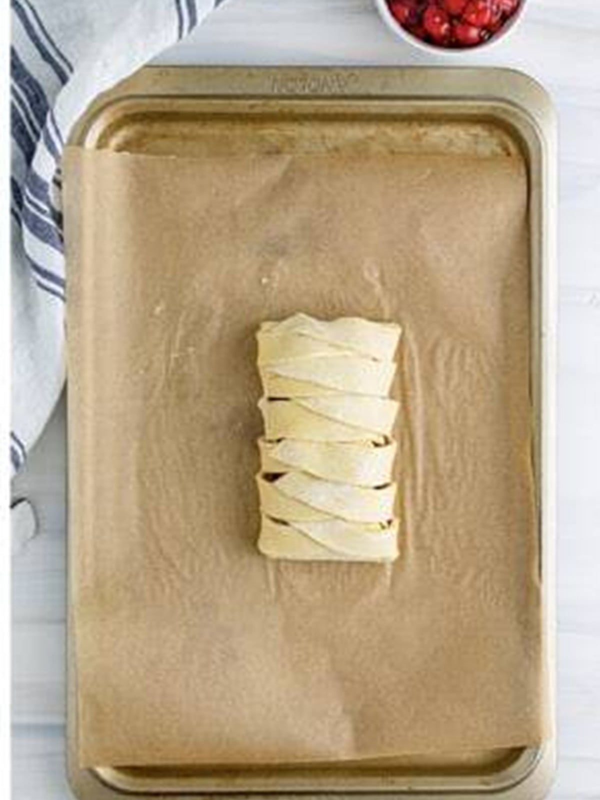 The strips of puff pastry braided over the filling.