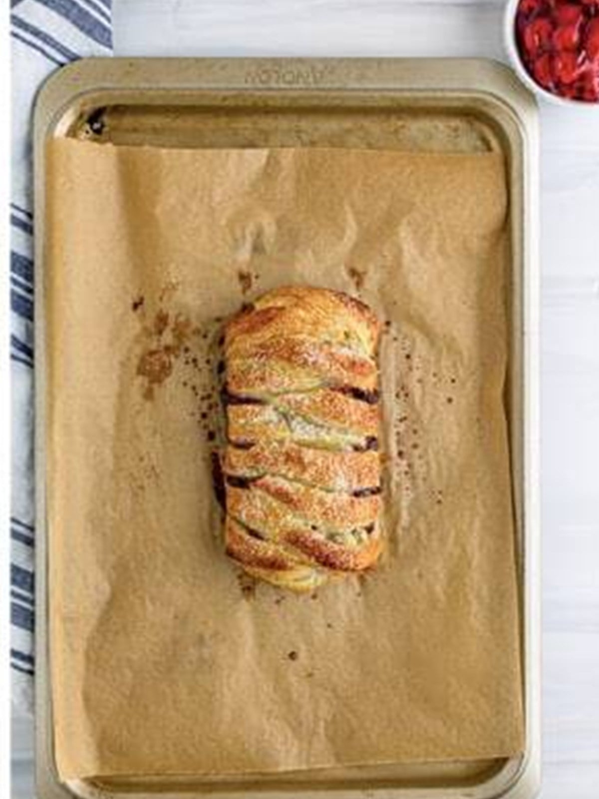 Golden brown baked black forest puff pastry braid on a sheet tray.