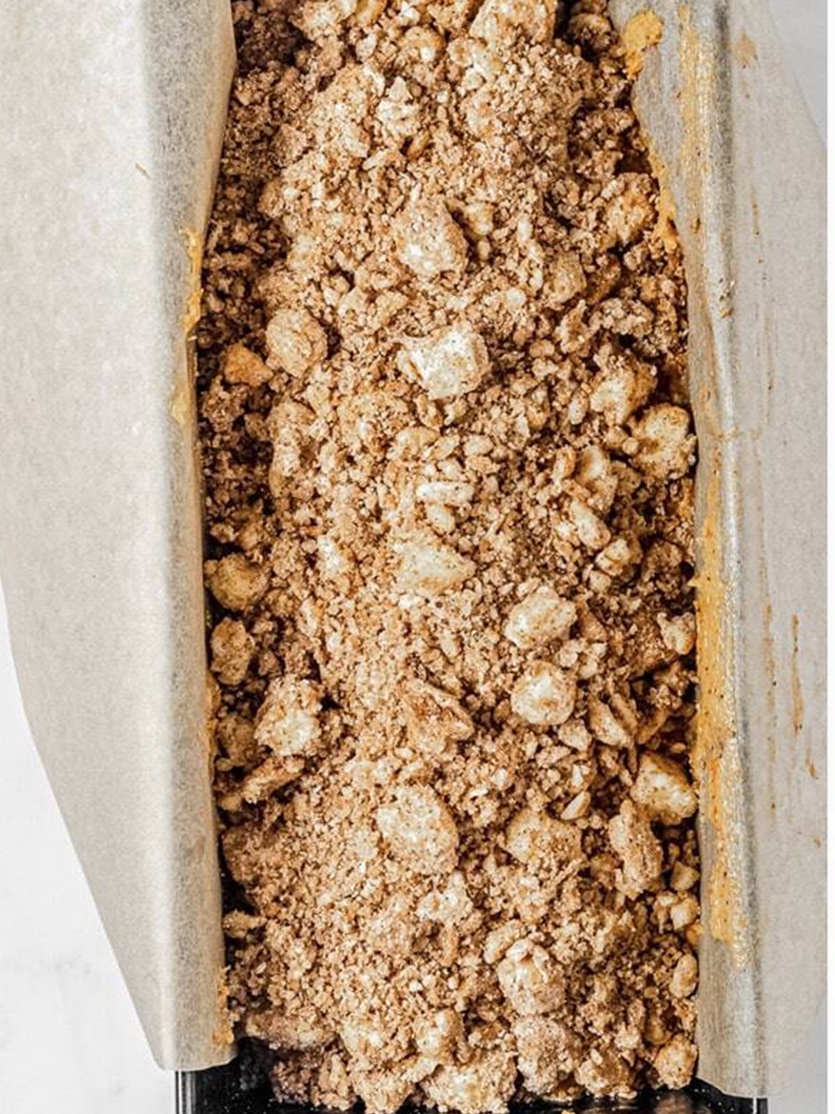 Streusel topping over pumpkin bread batter before baking