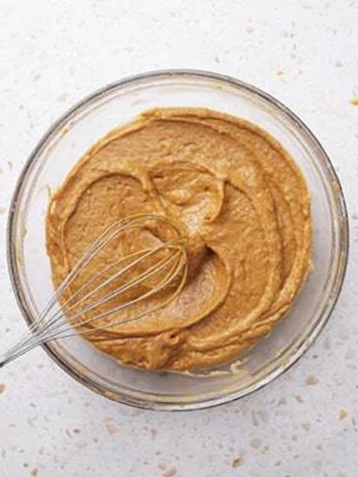 The finished smooth pumpkin bundt cake batter whisked in a glass bowl.