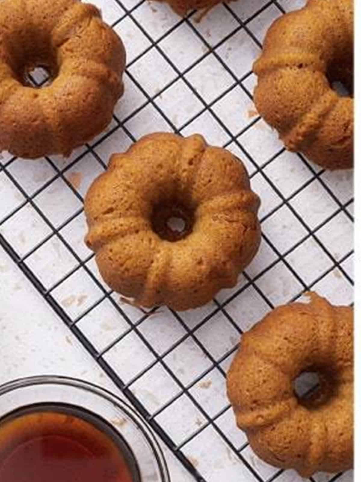 Baked mini pumpkin bundt cakes cooling on a wire rack.