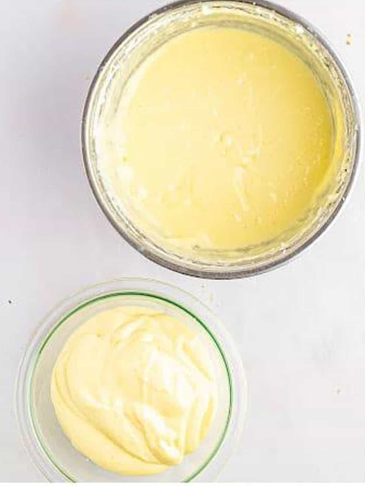 Bowls of plain cheesecake batter and pumpkin cheesecake batter side by side.