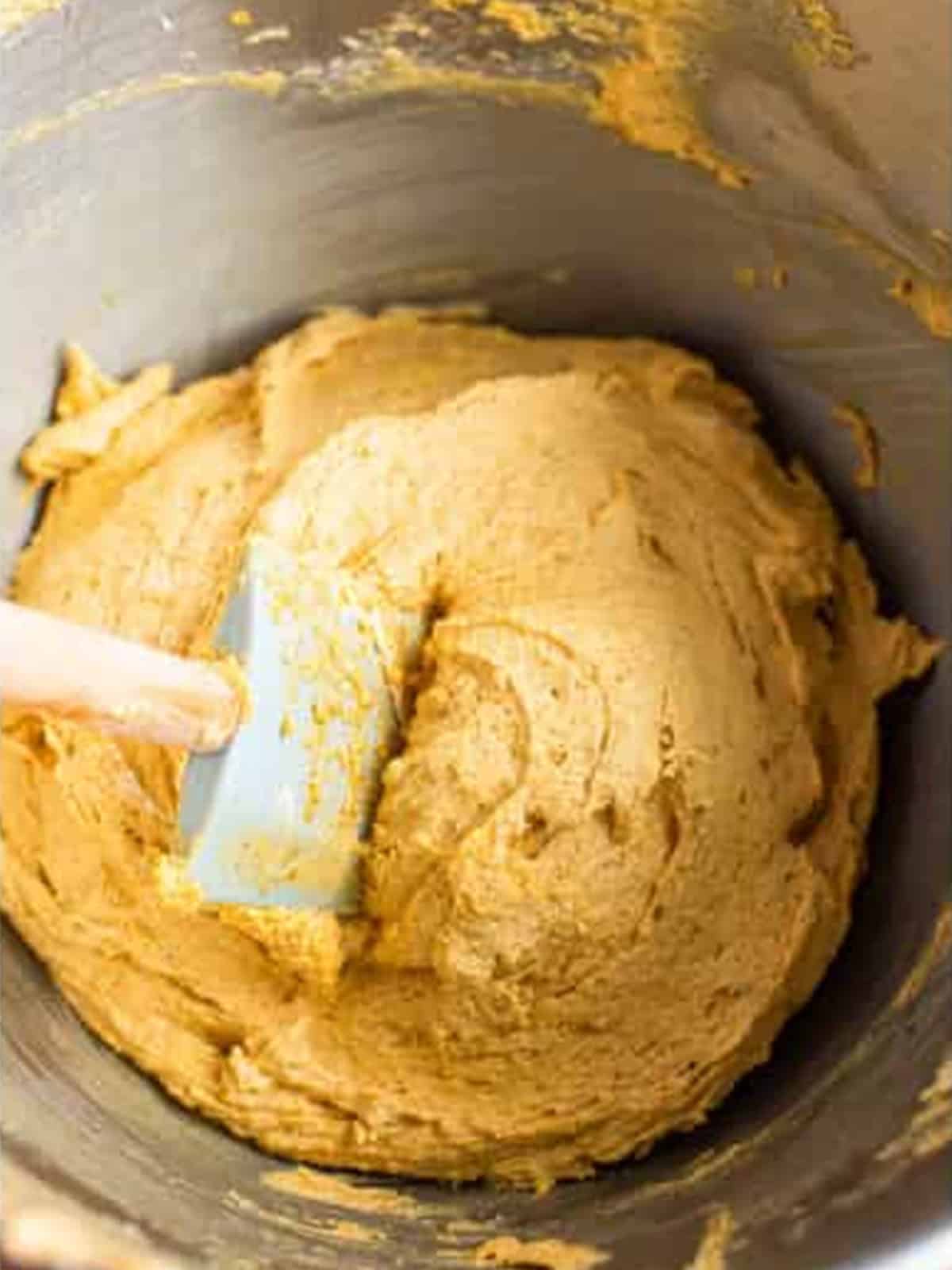 Smooth pumpkin cookie batter mixed together in a stand mixer bowl.