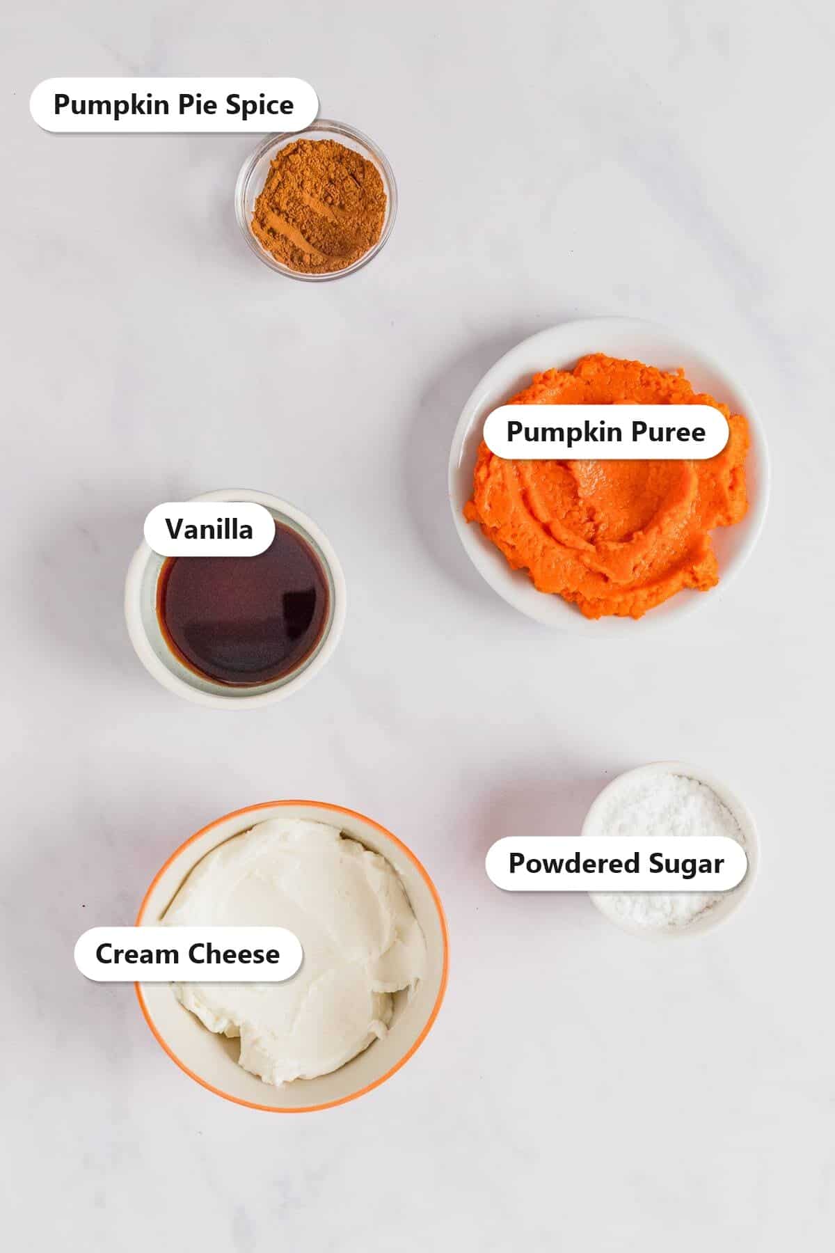 Ingredients to make pumpkin dip including pumpkin puree, cream cheese, powdered sugar, pumpkin pie spice, and vanilla.