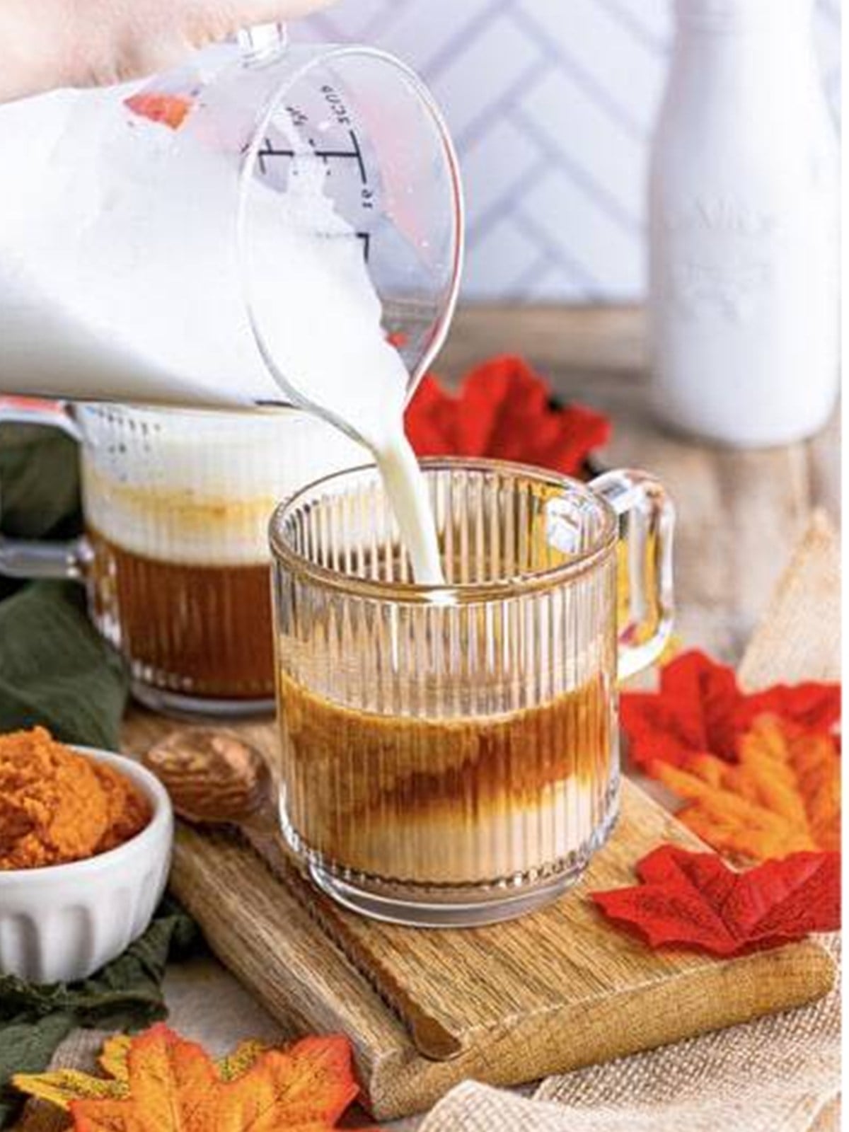 Frothed milk poured into a pumpkin spice latte.