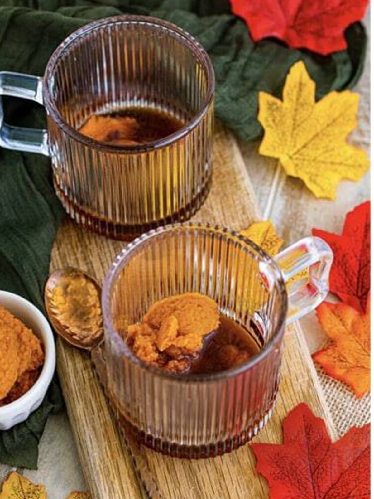 Pumpkin puree, maple syrup, vanilla, and pumpkin spice added to a clear glass mug for a copycat Starbucks pumpkin spice latte.