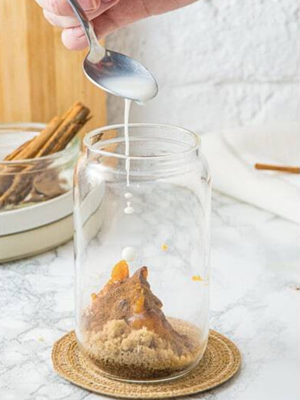 Pumpkin puree, brown sugar, pumpkin spice, and instant coffee combined with a splash of milk in a tall glass.
