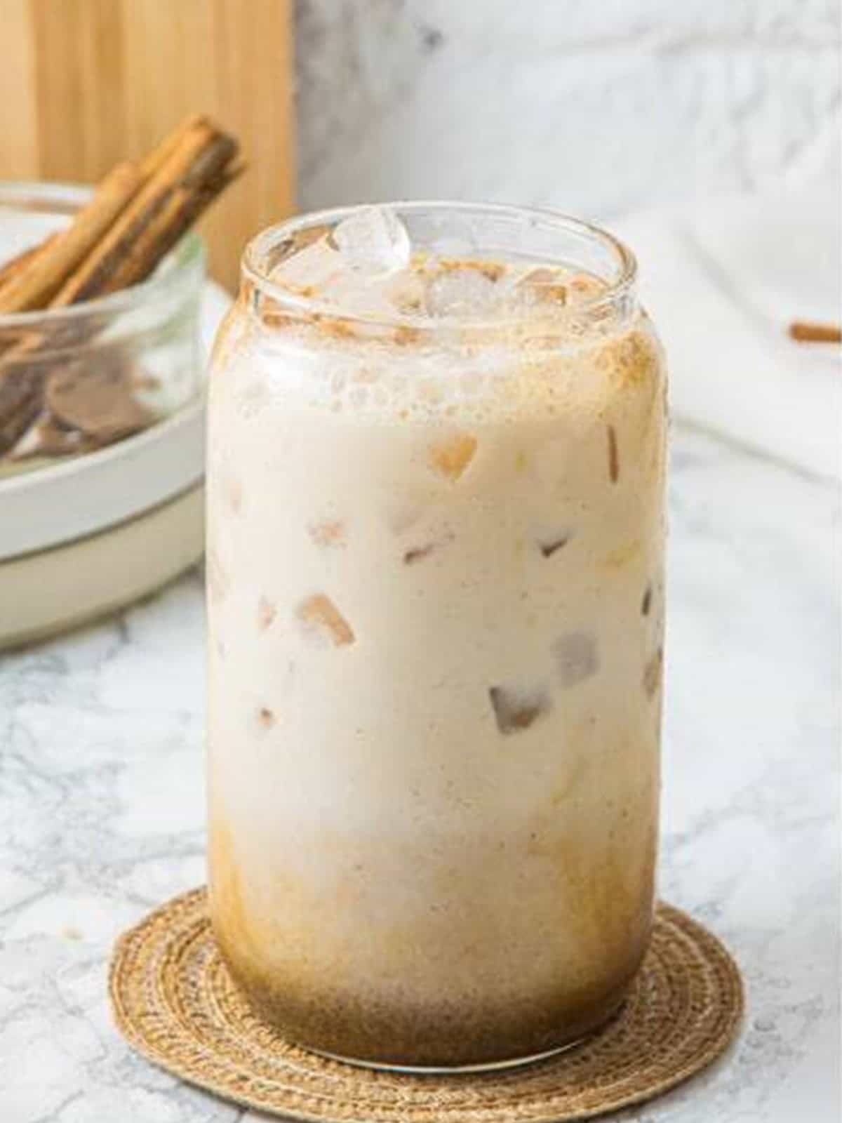 Cold milk poured over ice into the pumpkin spice latte glass.