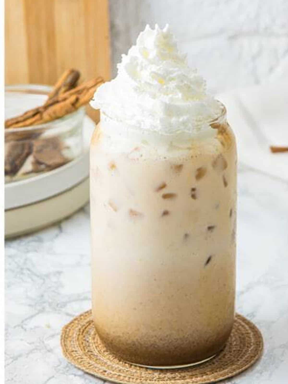 A pumpkin spice latte topped with a swirl of whipped cream.