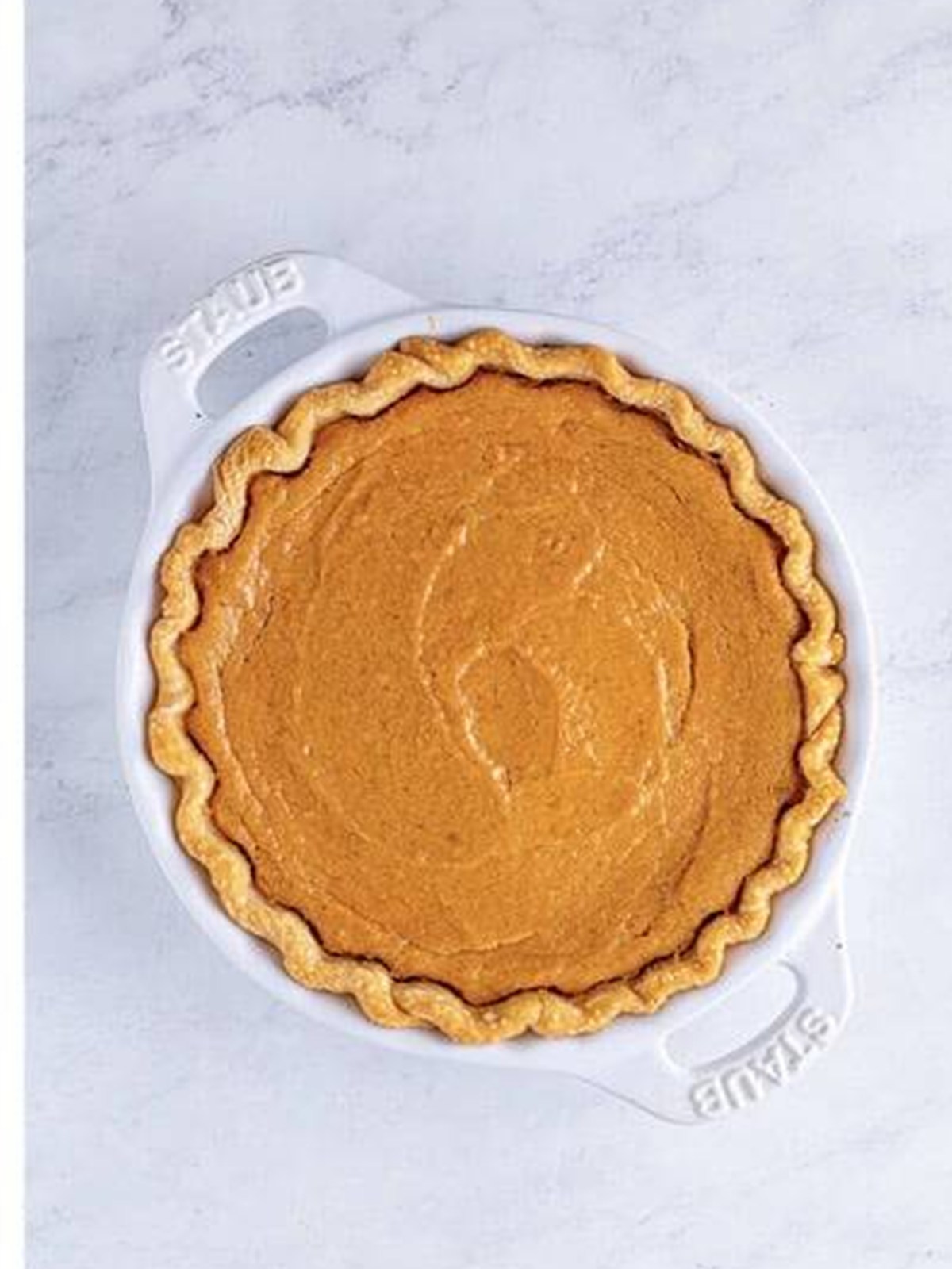 Baked golden sweet potato pie in a pie dish.