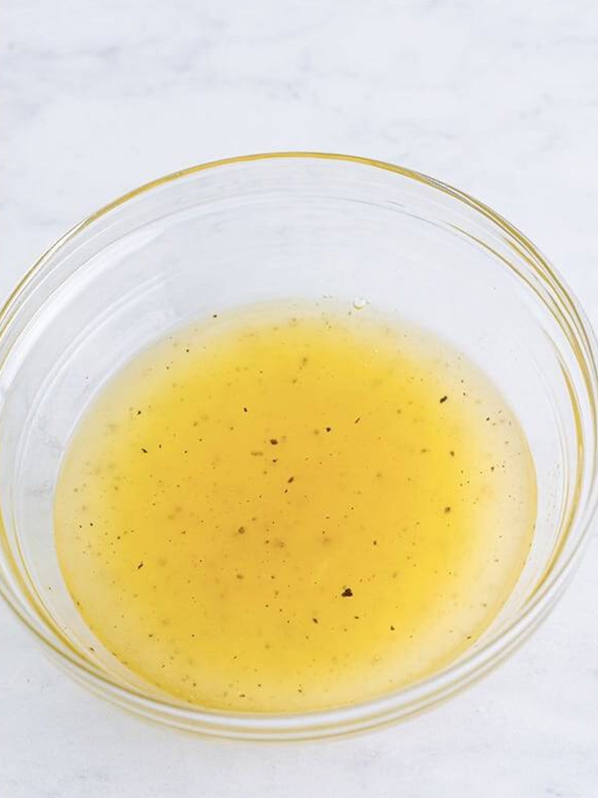 Sesame lemon dressing whisked together in a glass bowl.