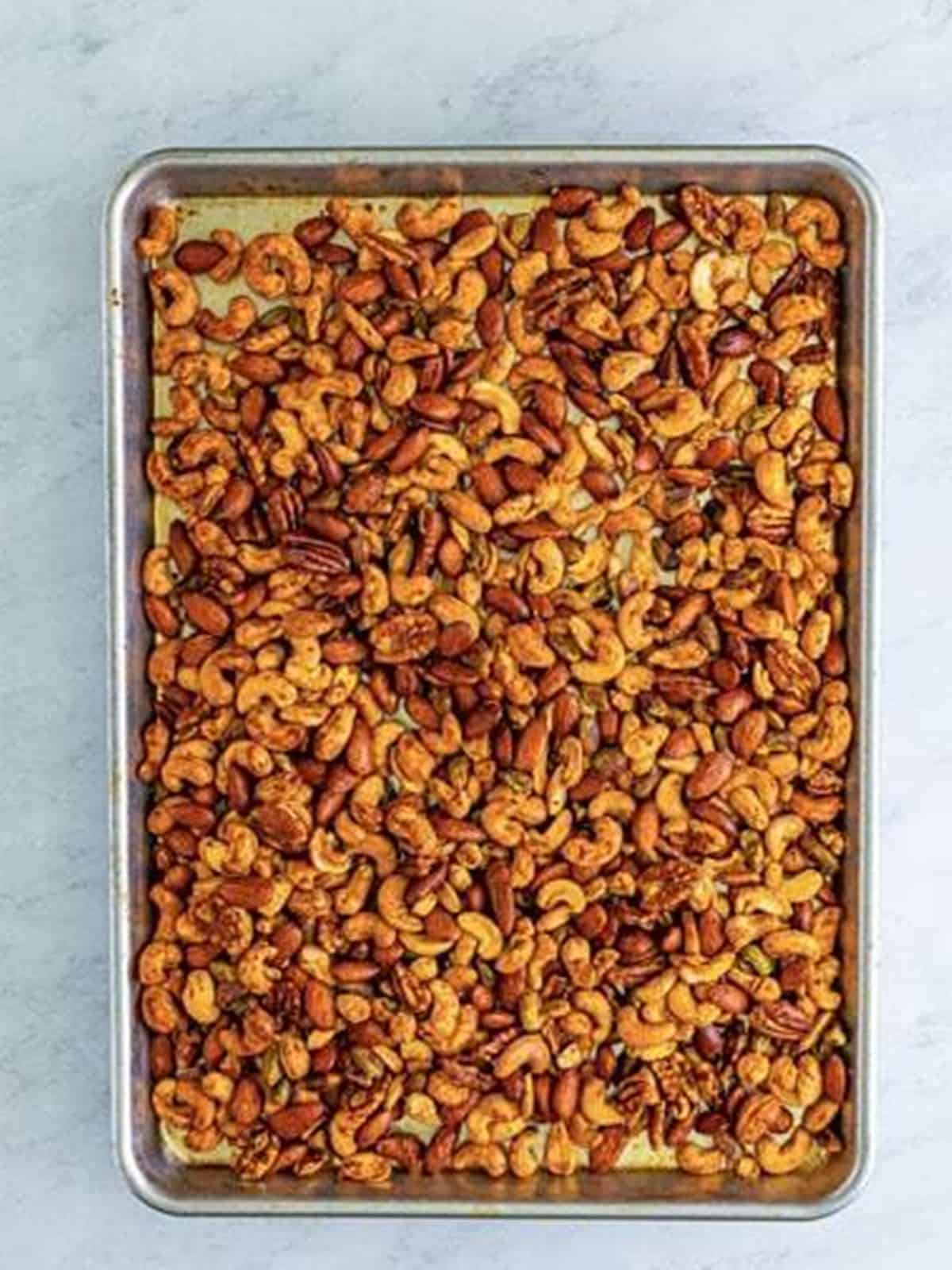 Buffalo ranch nuts roasted golden brown on a sheet tray.