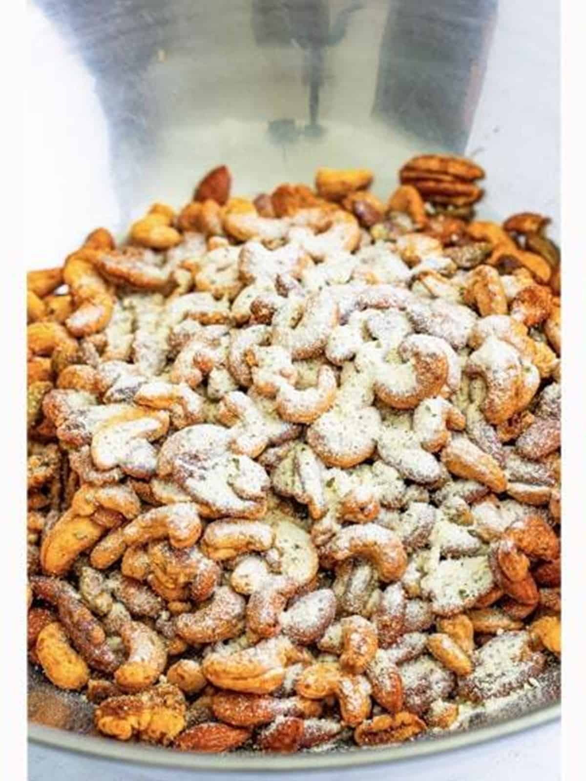 Roasted nuts tossed with dried ranch seasoning in a bowl.
