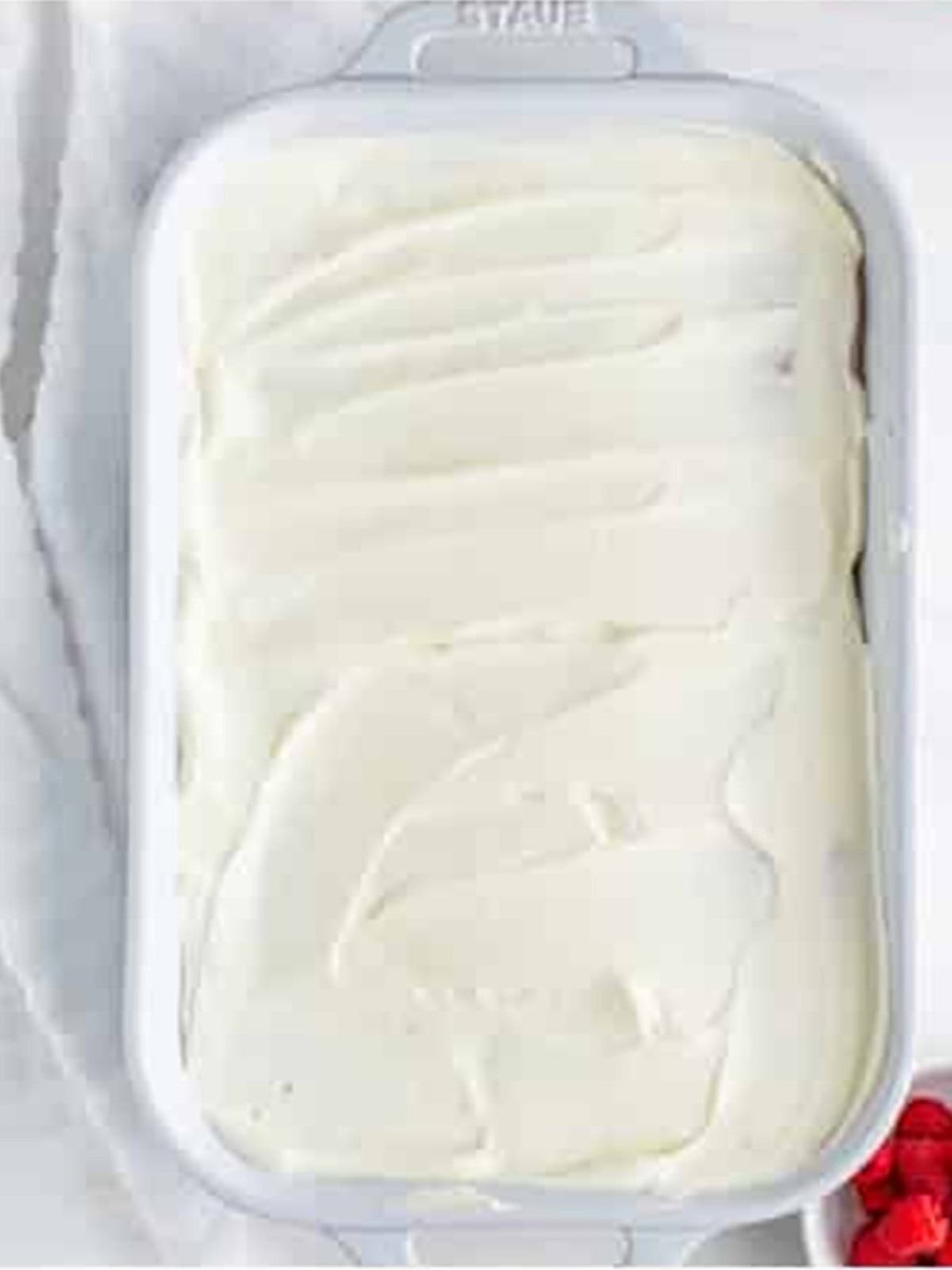 Plain whipped cream layer spread over the crackers for Raspberry Icebox Cake.