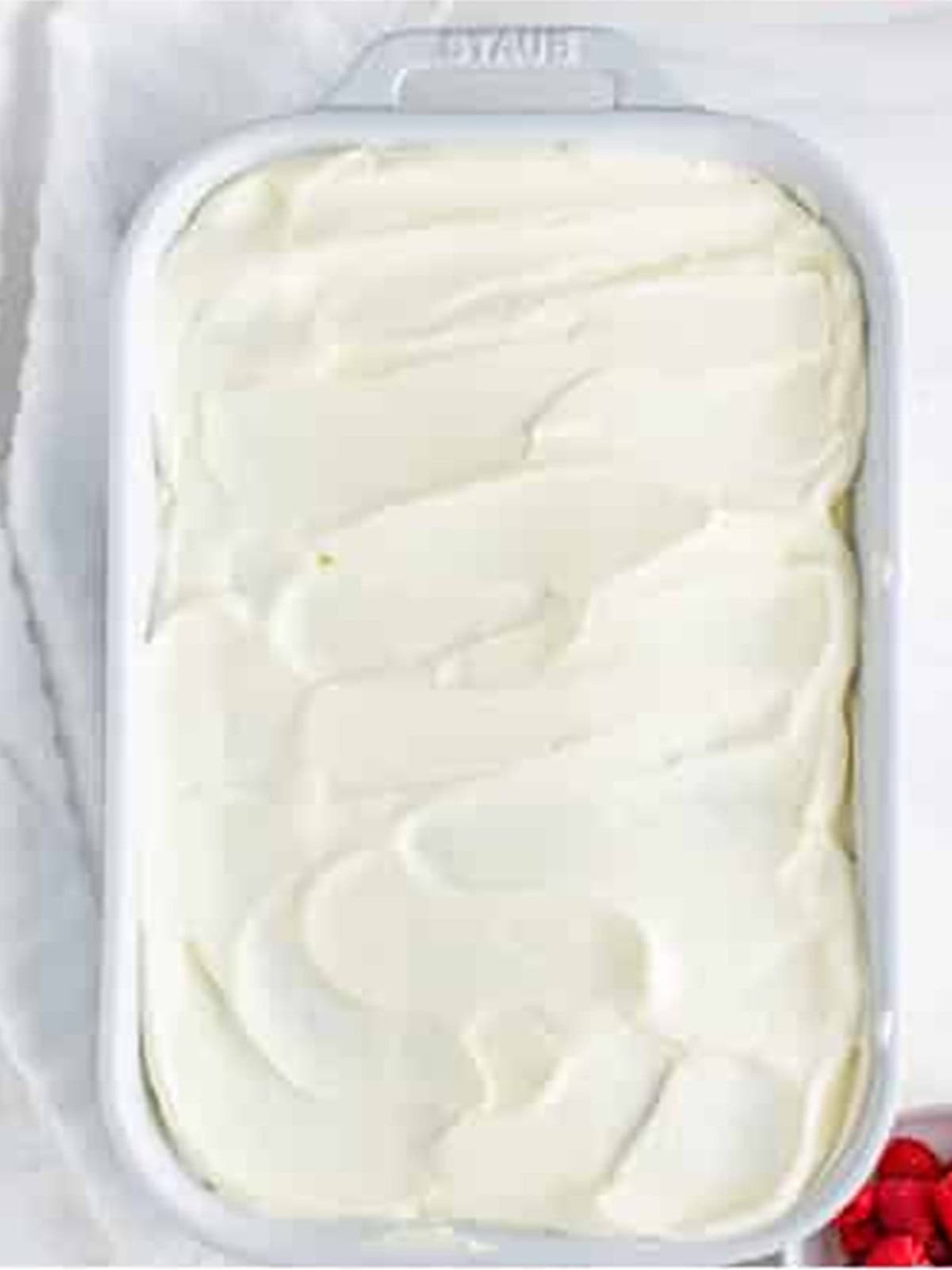 Raspberry Icebox Cake topped with smooth whipped cream ready to chill.