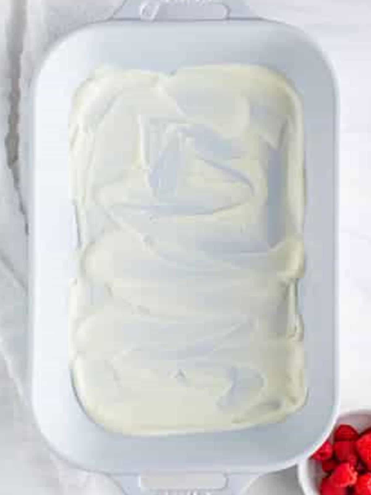 Plain whipped cream spread over the bottom of a 9x13 dish for Raspberry Icebox Cake.