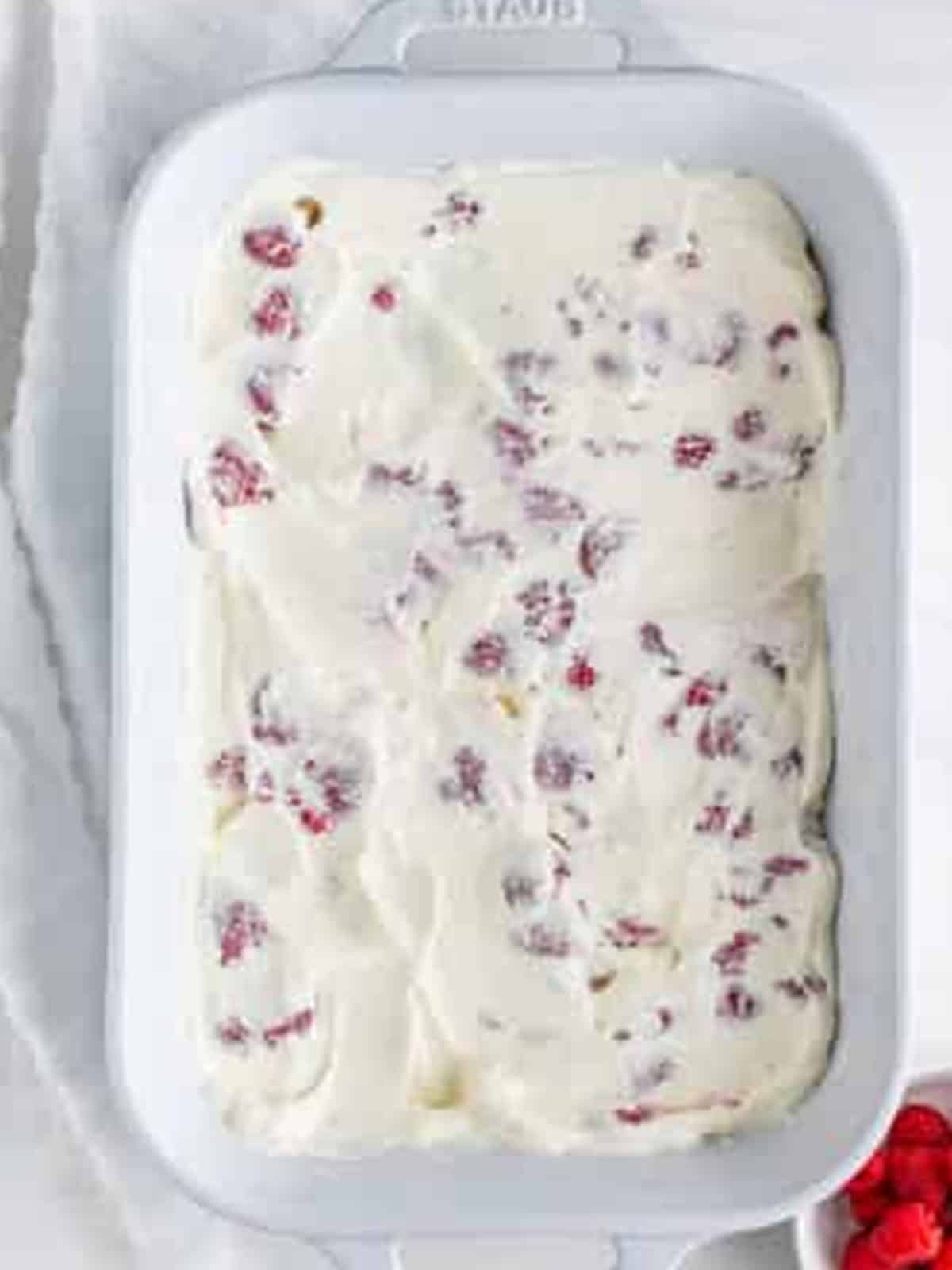 Fresh raspberry whipped cream layer smoothed to the edges for Raspberry Icebox Cake.