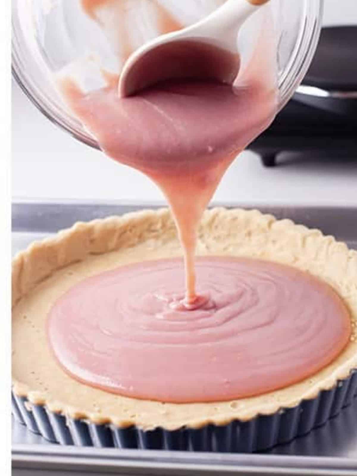 Pink raspberry white chocolate filling poured into the pre-baked tart crust.