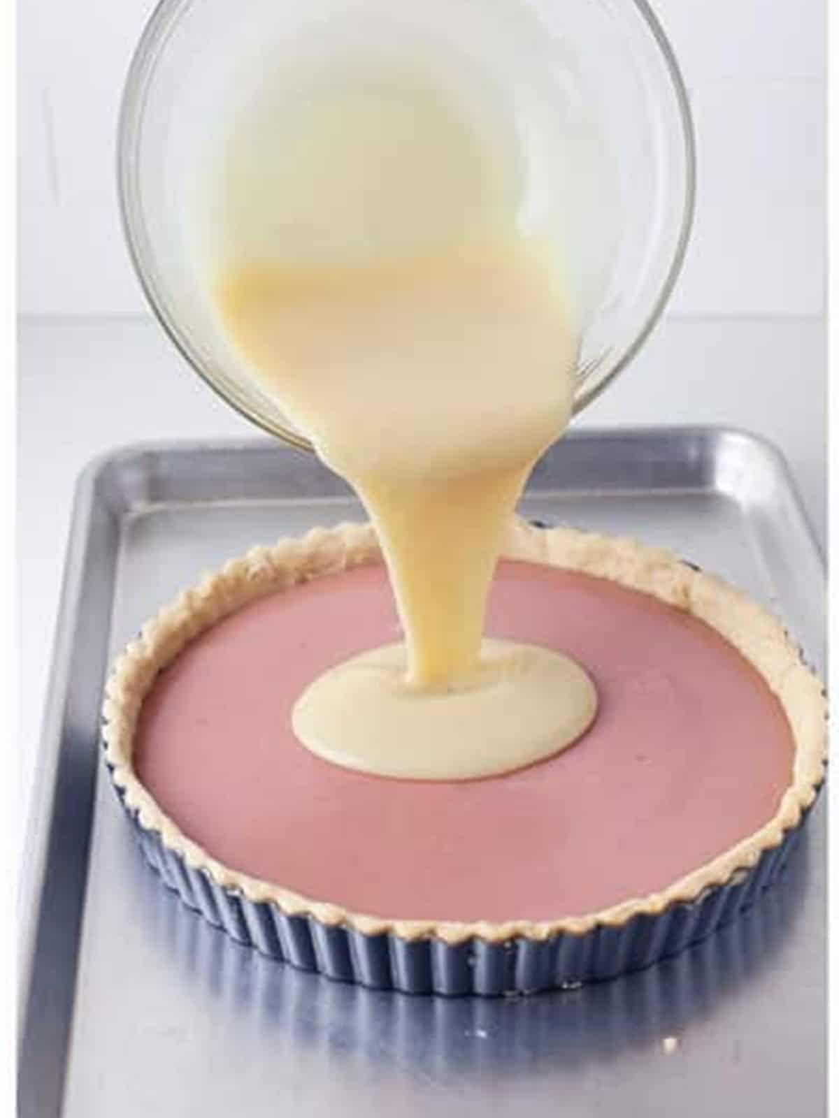 White chocolate cream layer poured over the raspberry layer in the tart.