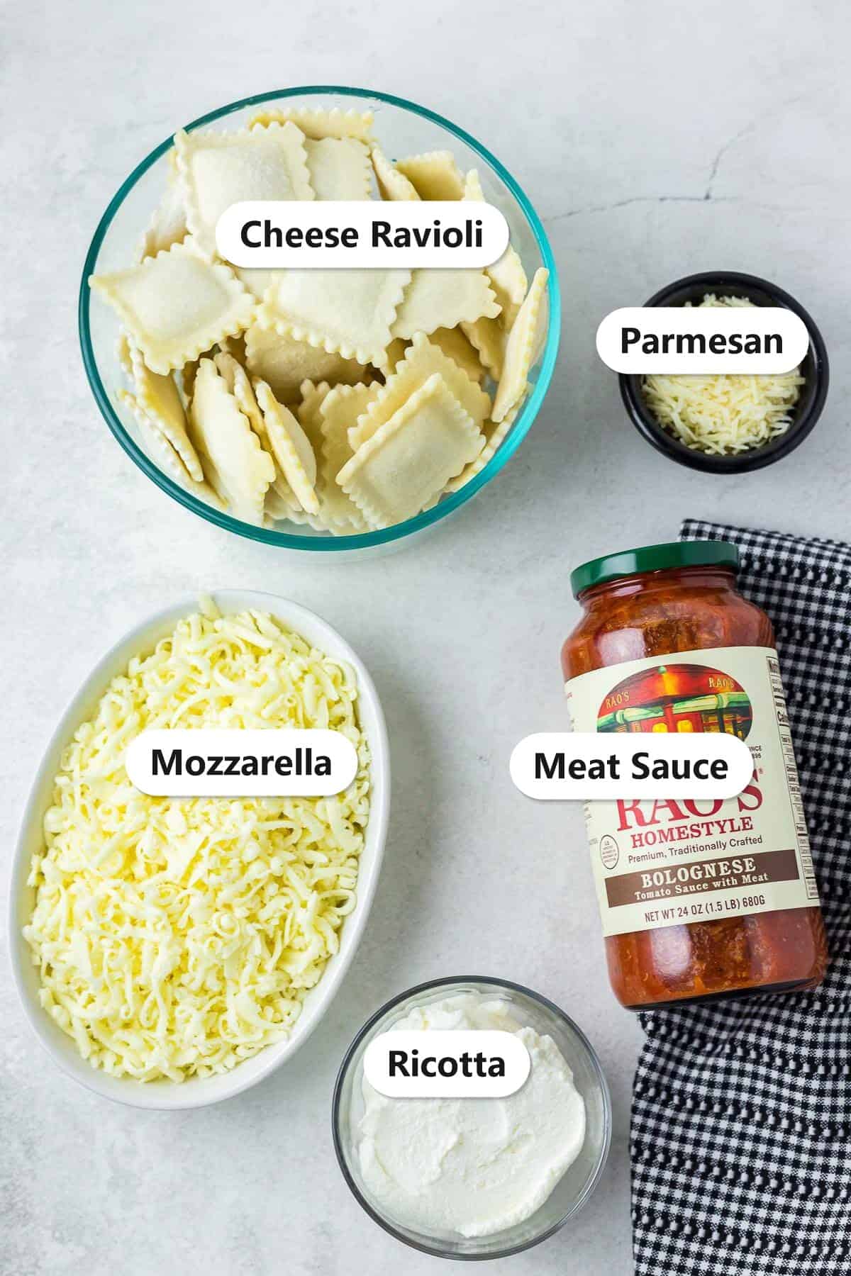 Labeled ingredients for ravioli lasagna including cheese ravioli, meat sauce, ricotta, mozzarella, and parmesan.