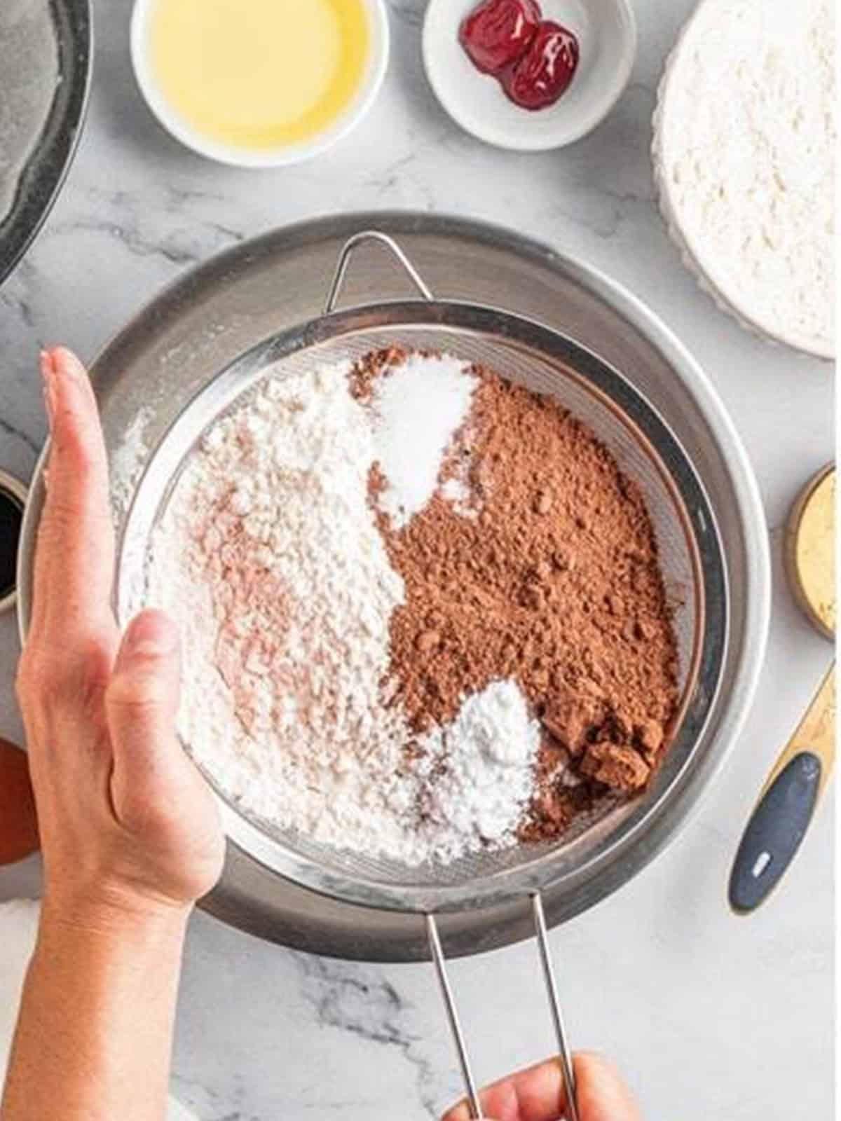 Flour and cocoa powder whisked together in a mixing bowl.