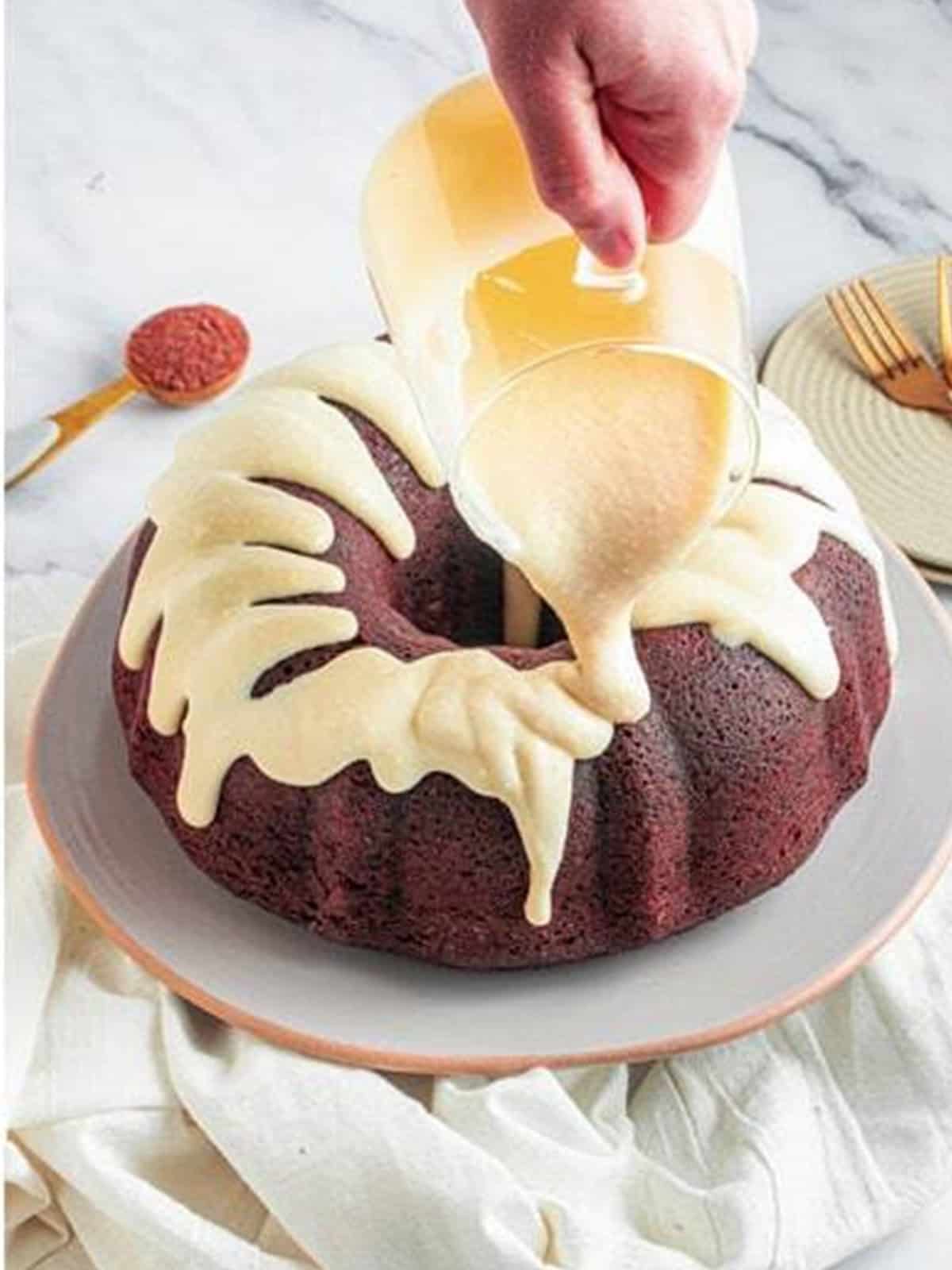Cream cheese glaze drizzled over the cooled red velvet bundt cake.