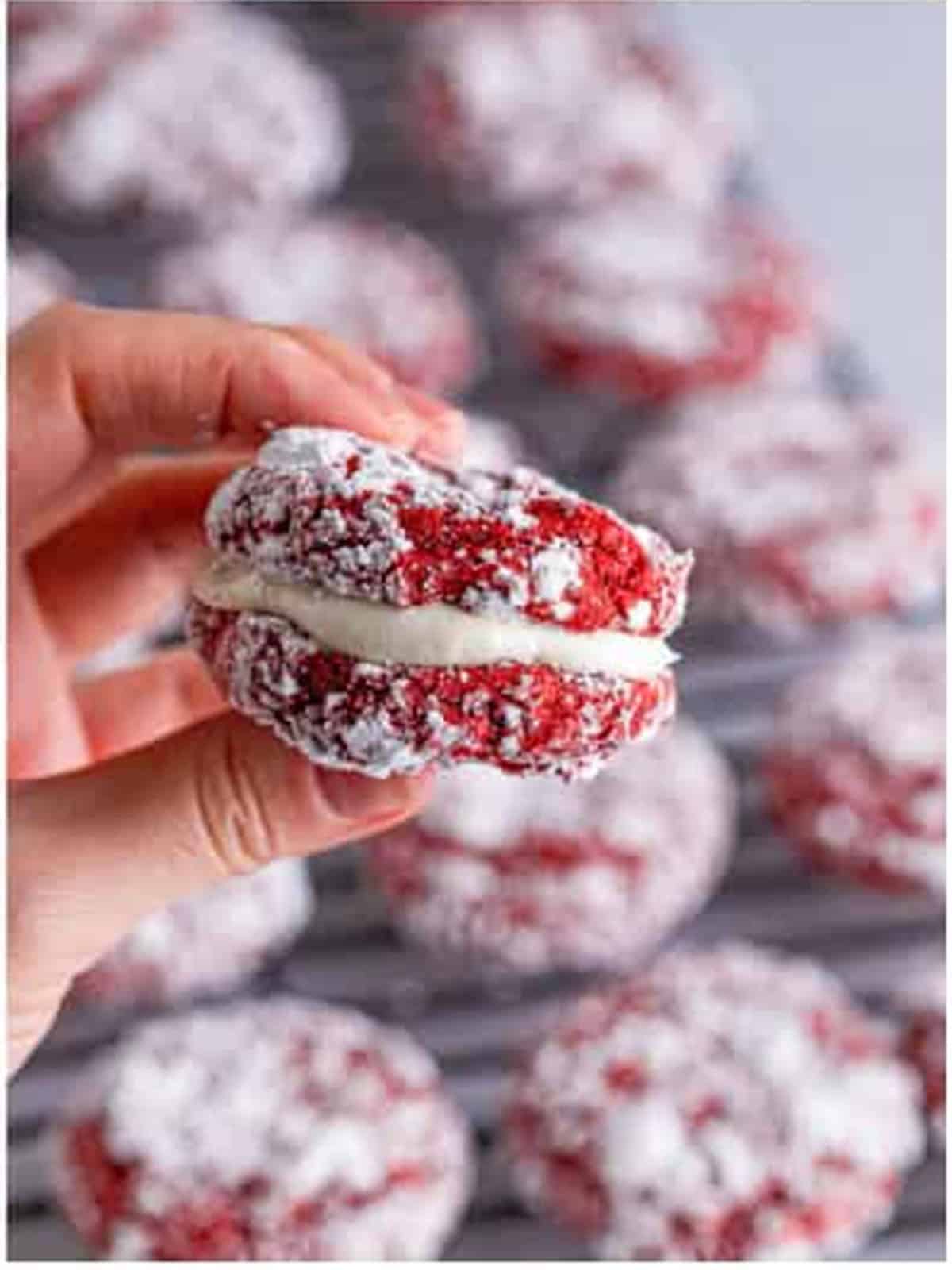 Assembled red velvet sandwich cookies filled with cream cheese frosting.