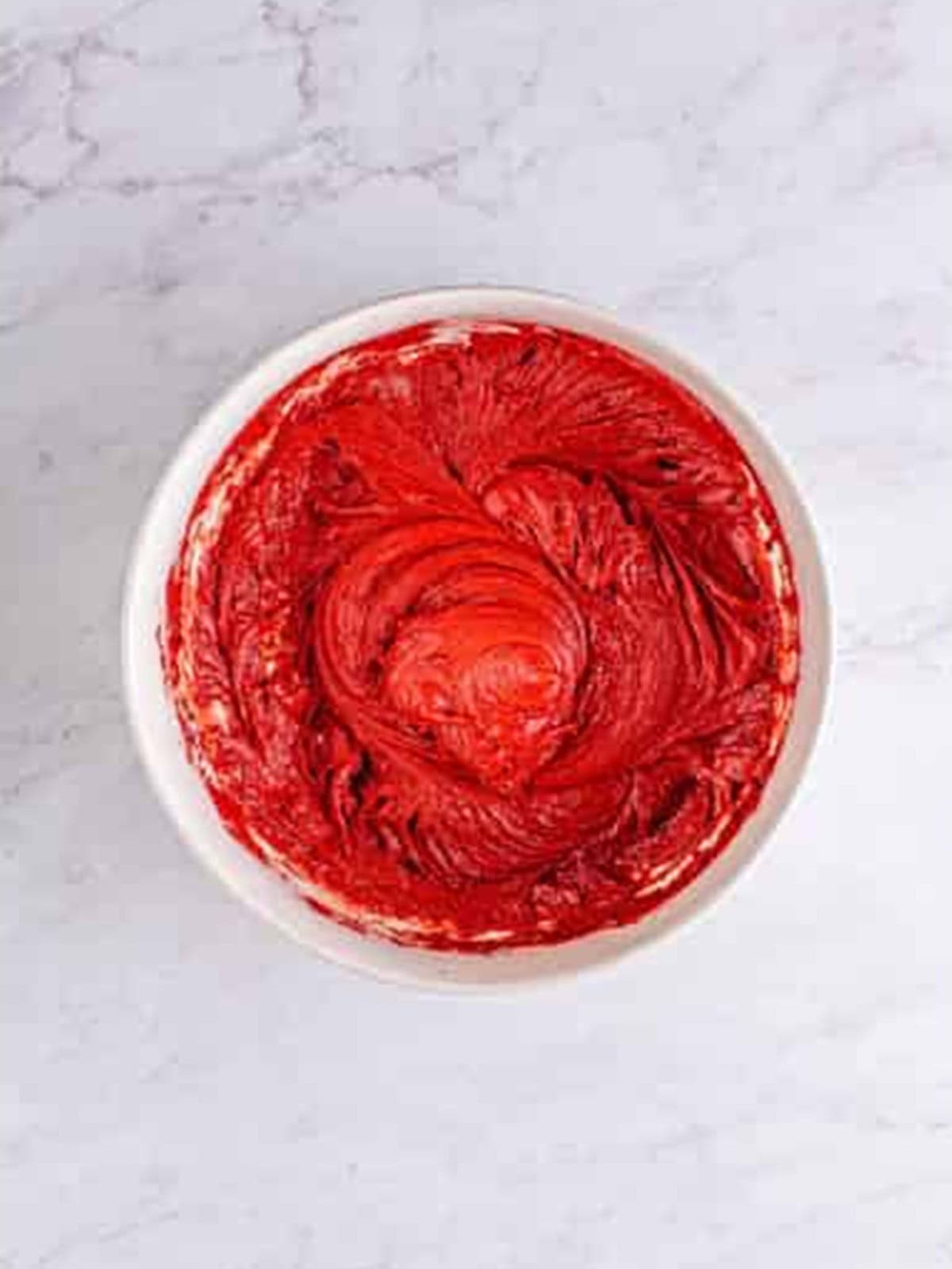 Red velvet cookie dough mixed smooth in a white bowl.