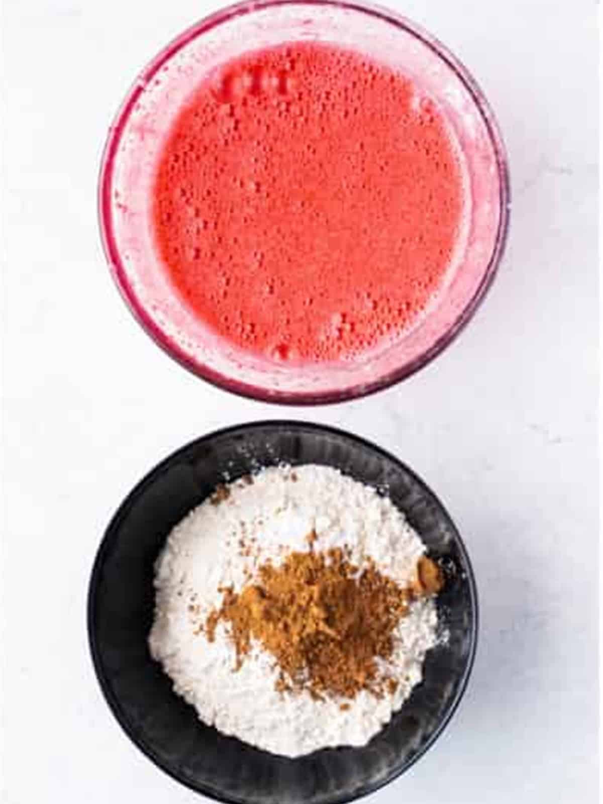Bright red velvet cupcake batter mixed together in a bowl.