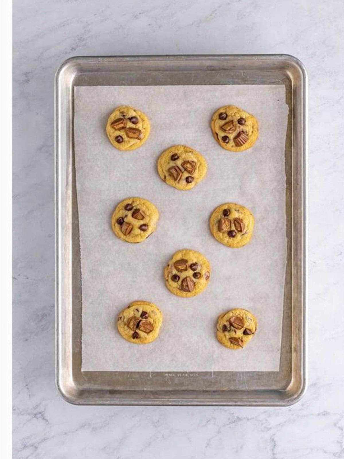 Baked Reese's Peanut Butter Cup Cookies garnished with extra candy on the tray.