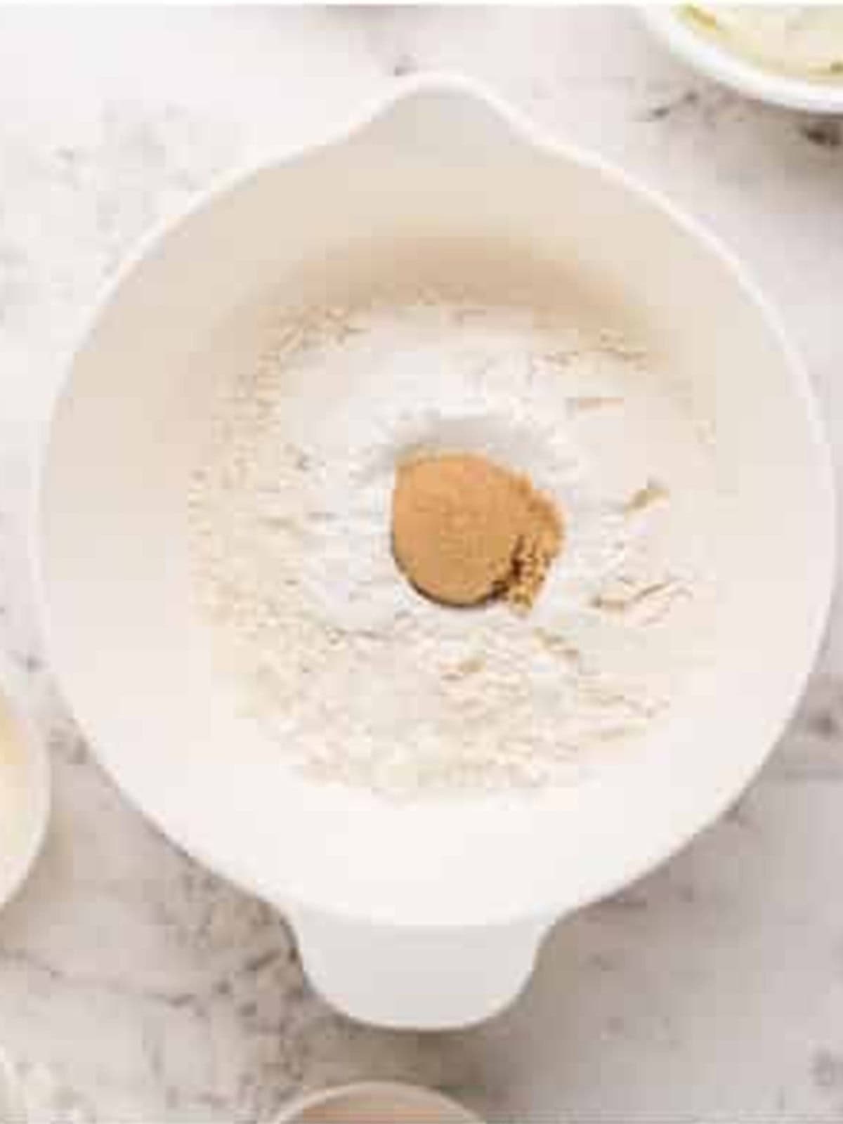 Flour, baking powder, and brown sugar whisked together in a bowl.