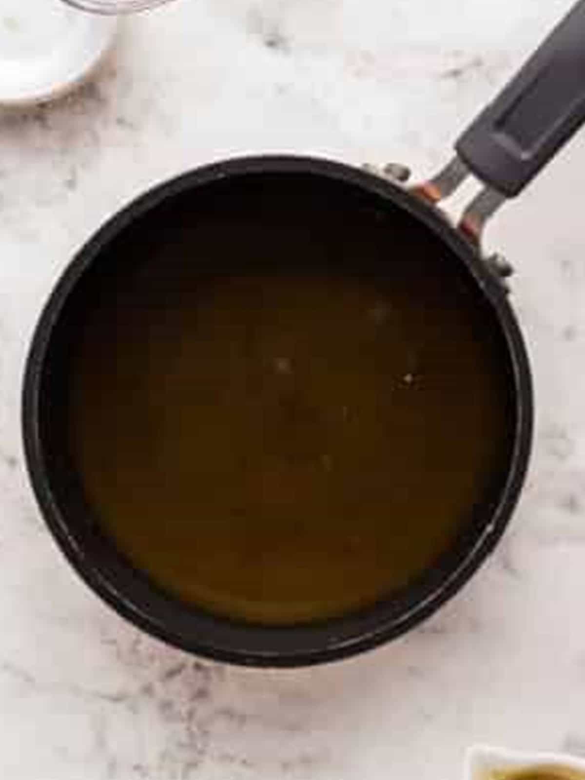 Amaretto maple syrup simmering in a saucepan.