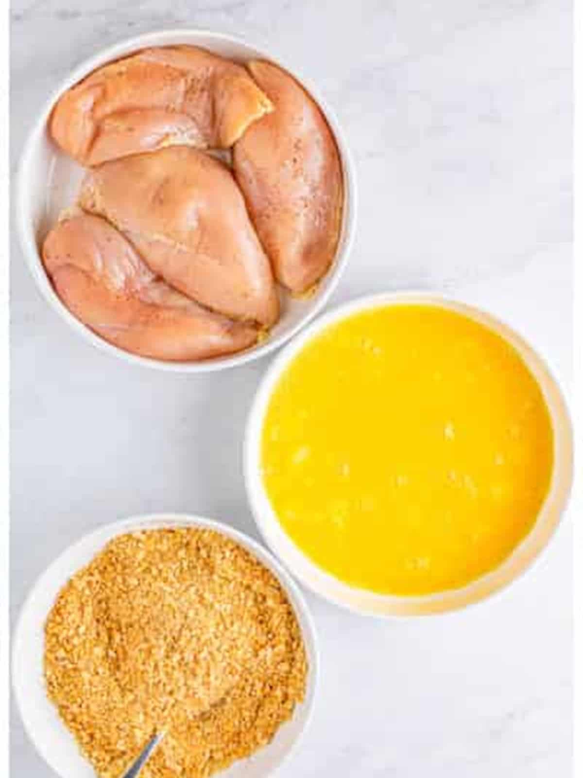 Bowls of chicken, egg, and crushed Ritz crackers for Ritz cracker chicken.
